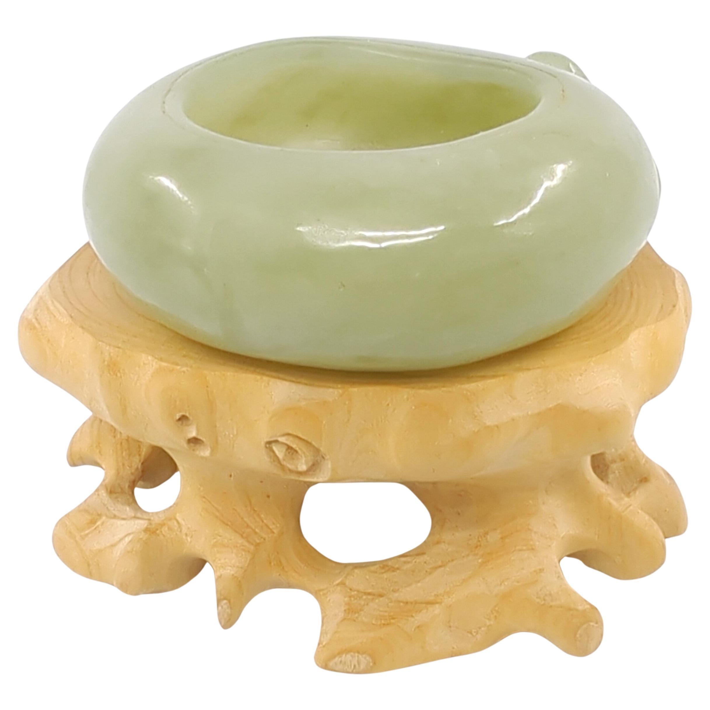 This exceptional celadon jade brush wash epitomizes the pinnacle of Chinese craftsmanship. Carved in the form of a hollowed peach, the piece showcases intricate detailing and a high level of artistry. The jade itself is of a delicate celadon hue,