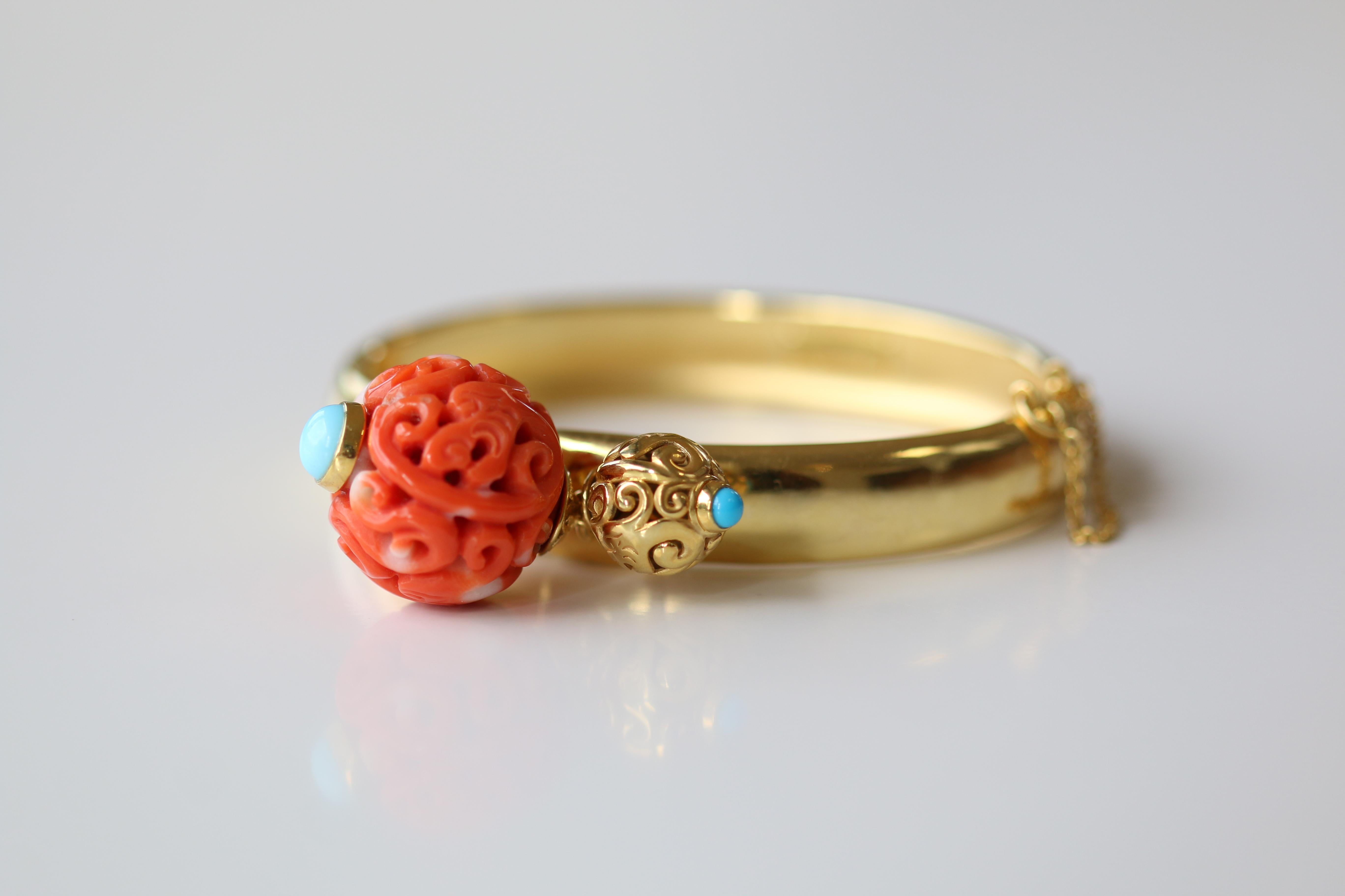 This bangle has been made with an antique Qing dynasty Chinese carved coral bead. The bead is intricate in its design and the swirls give it a wonderful, instantly recognisable,  Oriental feel. Next to the coral bead is a gold one, moulded in the