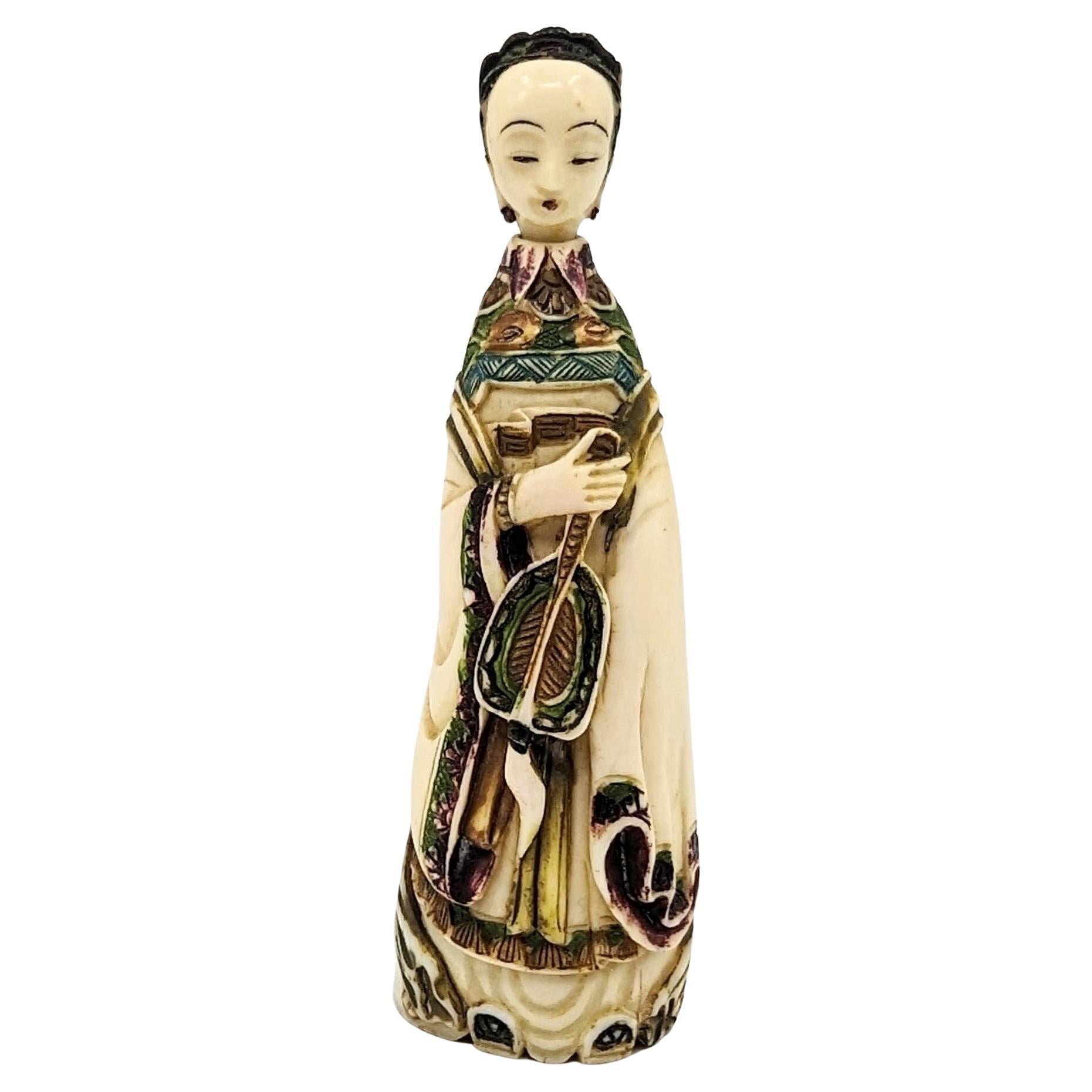 Antique and tastefully carved natural material Chinese snuff bottle in the form of a well dressed court lady holding a fan. The lady figure holds a peaceful and meditative smile, with eyes semi-closed, and thin lips glossed in purple, matching