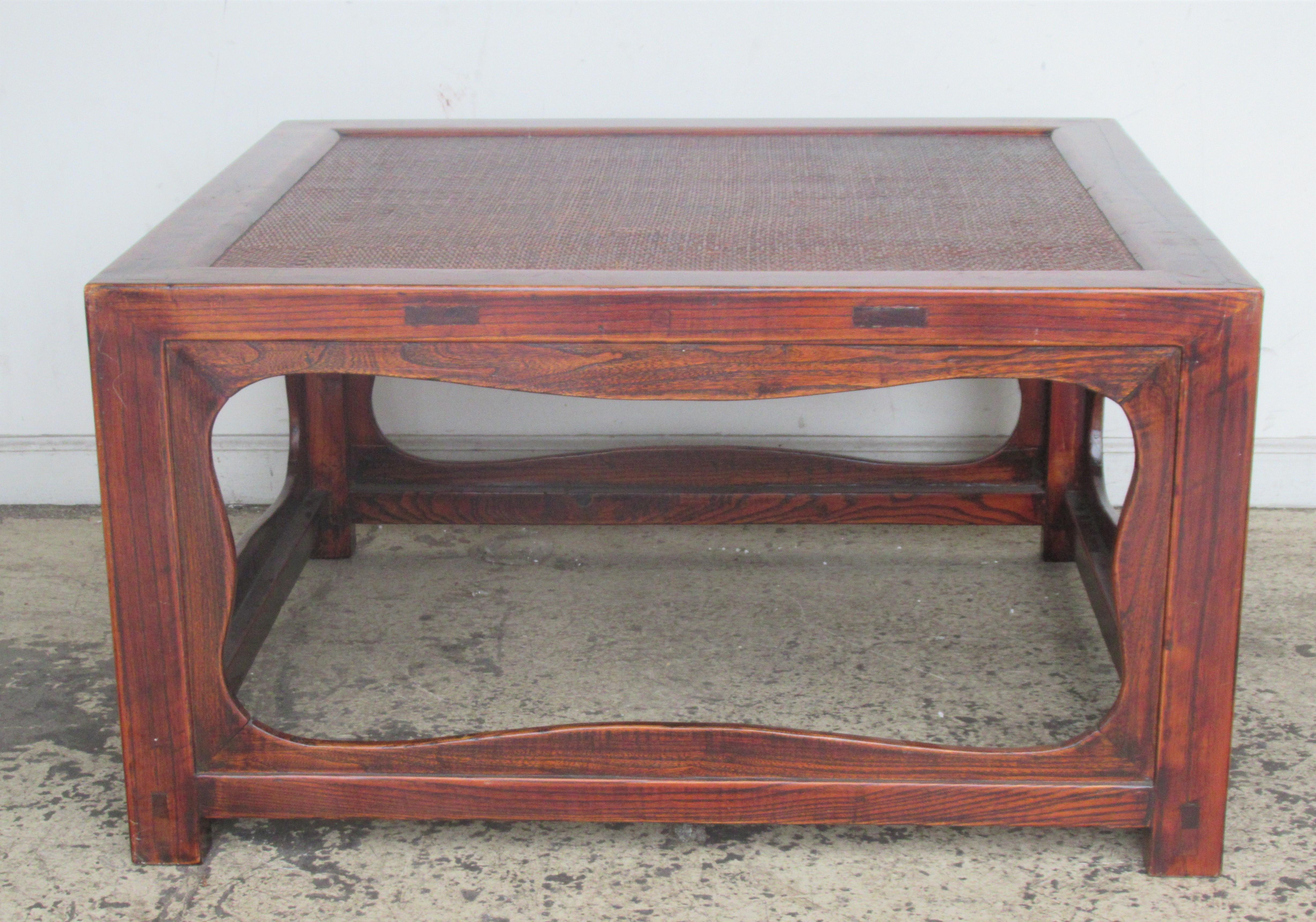 Antique Chinese carved elm coffee table w/ inset cane top. Rich natural grain to elm wood with overall beautifully aged glowing surface color to original finish, circa 1900. Great looking table. Look at all pictures and read condition report in