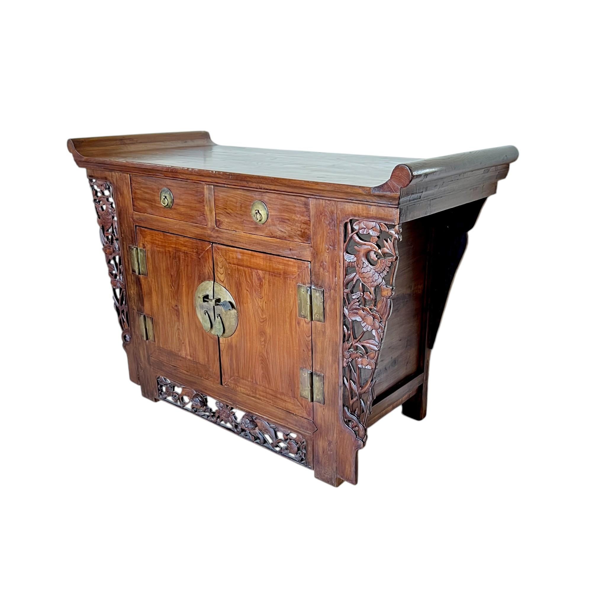 Un excepcional mueble de altar o mesa cofre de madera noble tallada de la dinastía Qing. Hecha a mano en madera de olmo al estilo tradicional chino, con ensamblaje de mortaja y espiga, tiene los extremos superiores evertidos, dos cajones superiores
