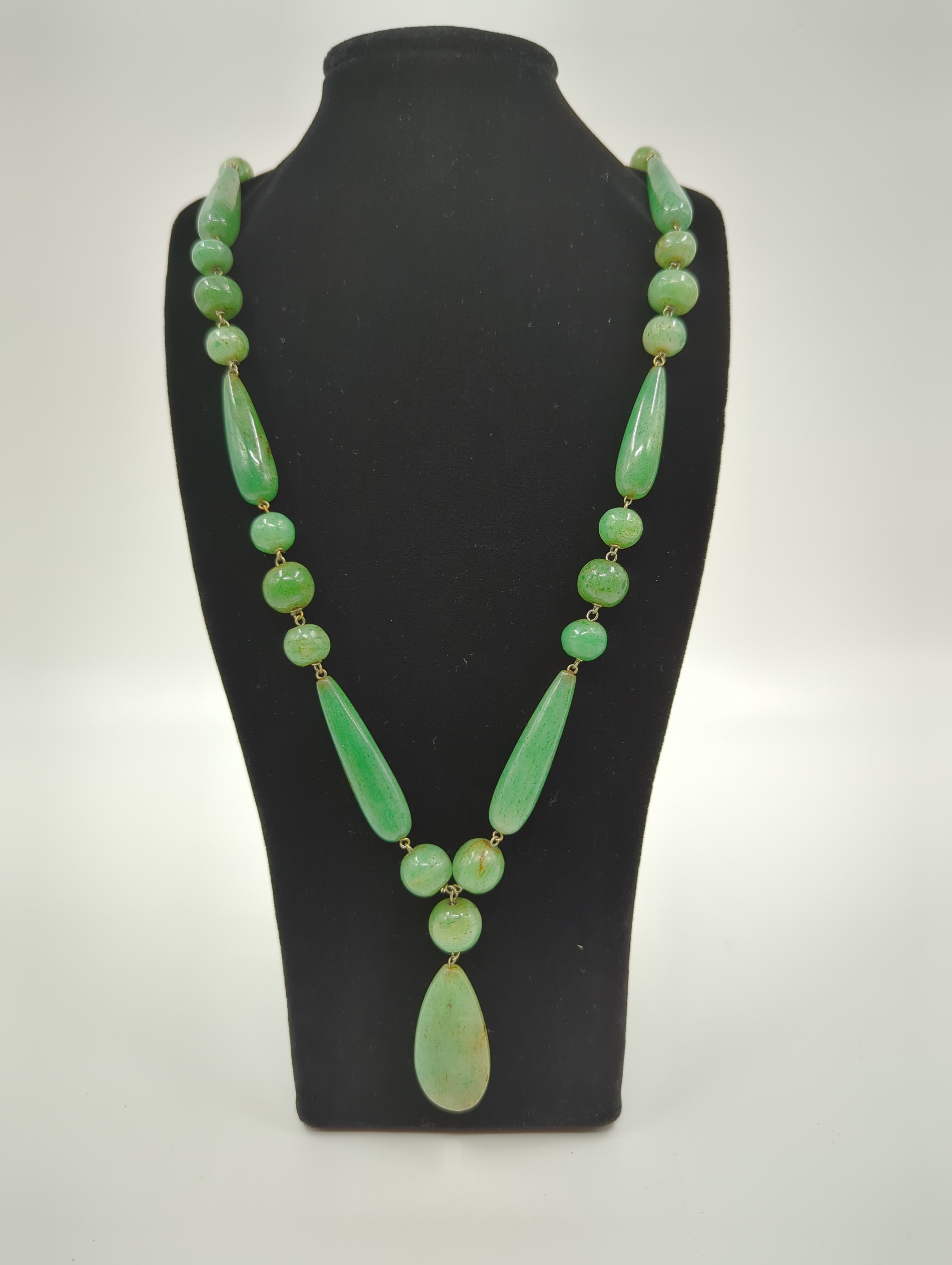 This late 19c carved green nephrite jade pendant and beads necklace, with a total length of 32 inches, makes a versatile and sophisticated accessory. The beads are strung together on delicate yet strong silver wires.

The clarity, size and