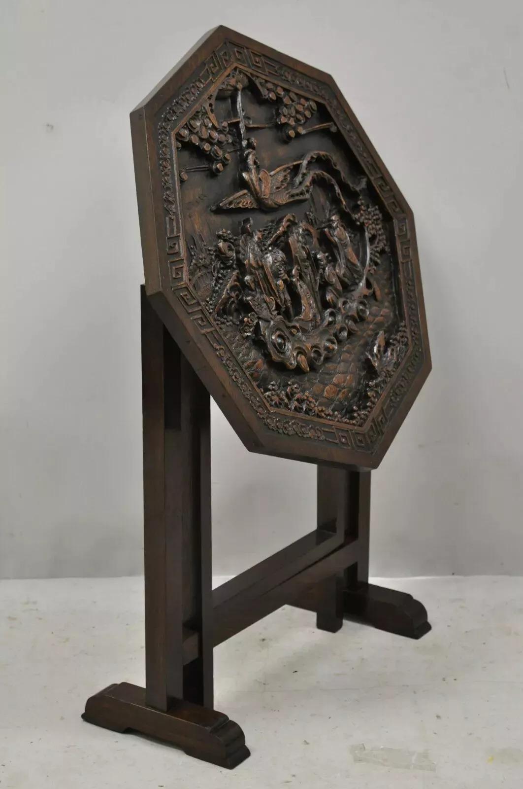Ancienne table chinoise pliante en bois dur sculpté avec des sculptures figuratives. Cet article présente une figurine sculptée en relief sur le dessus, une base dépliable, un couvercle rabattable, une construction en bois massif, un très bel