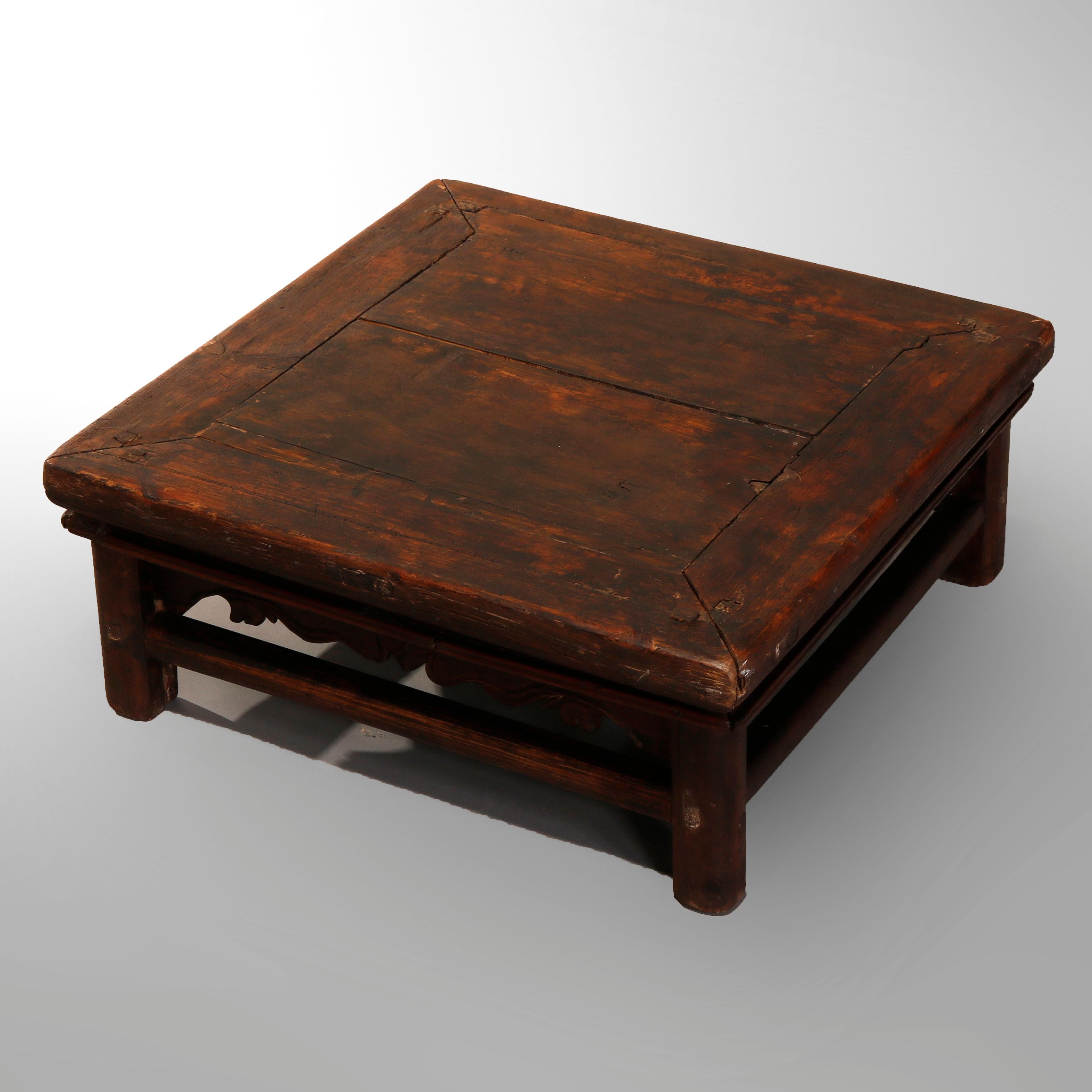 An antique Chinese low table offers pegged hardwood construction with top surmounting foliate hand carved skirt, raised on straight legs, 19th century

Measures: 10.25
