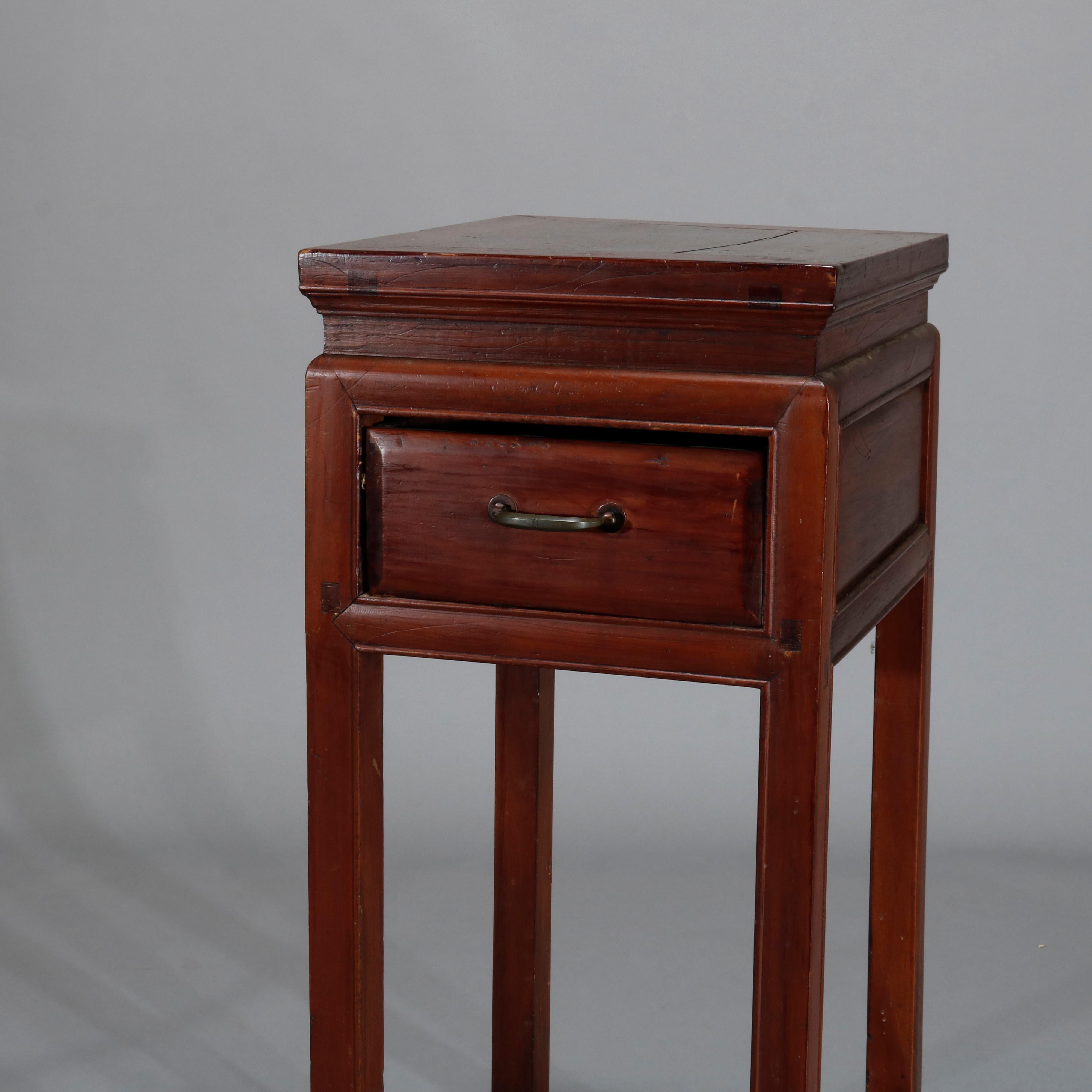 An antique Chinese side stand offers hardwood construction with single drawer having cast bronze pull and over slat lower shelf, raised on square and straight legs, 19th century

Measures: 33.75