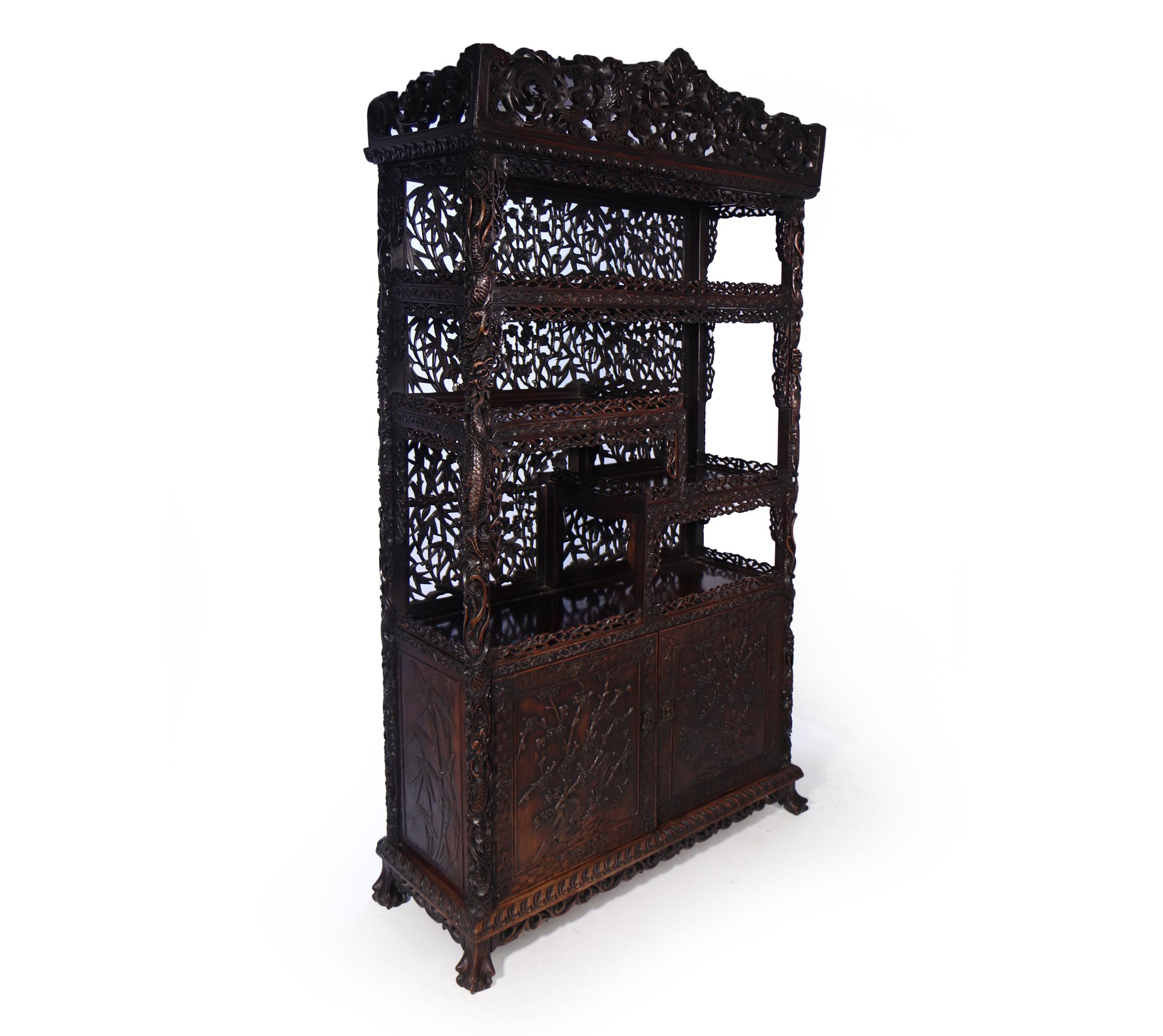 This Intricately carved Hongmu this multi layered cabinet with removable pediment, the cabinet is carved heavily with Dragons and exotic fruits and flowers, the lower doors have cherry blossom carved in the panels. This all stands on ball and claw