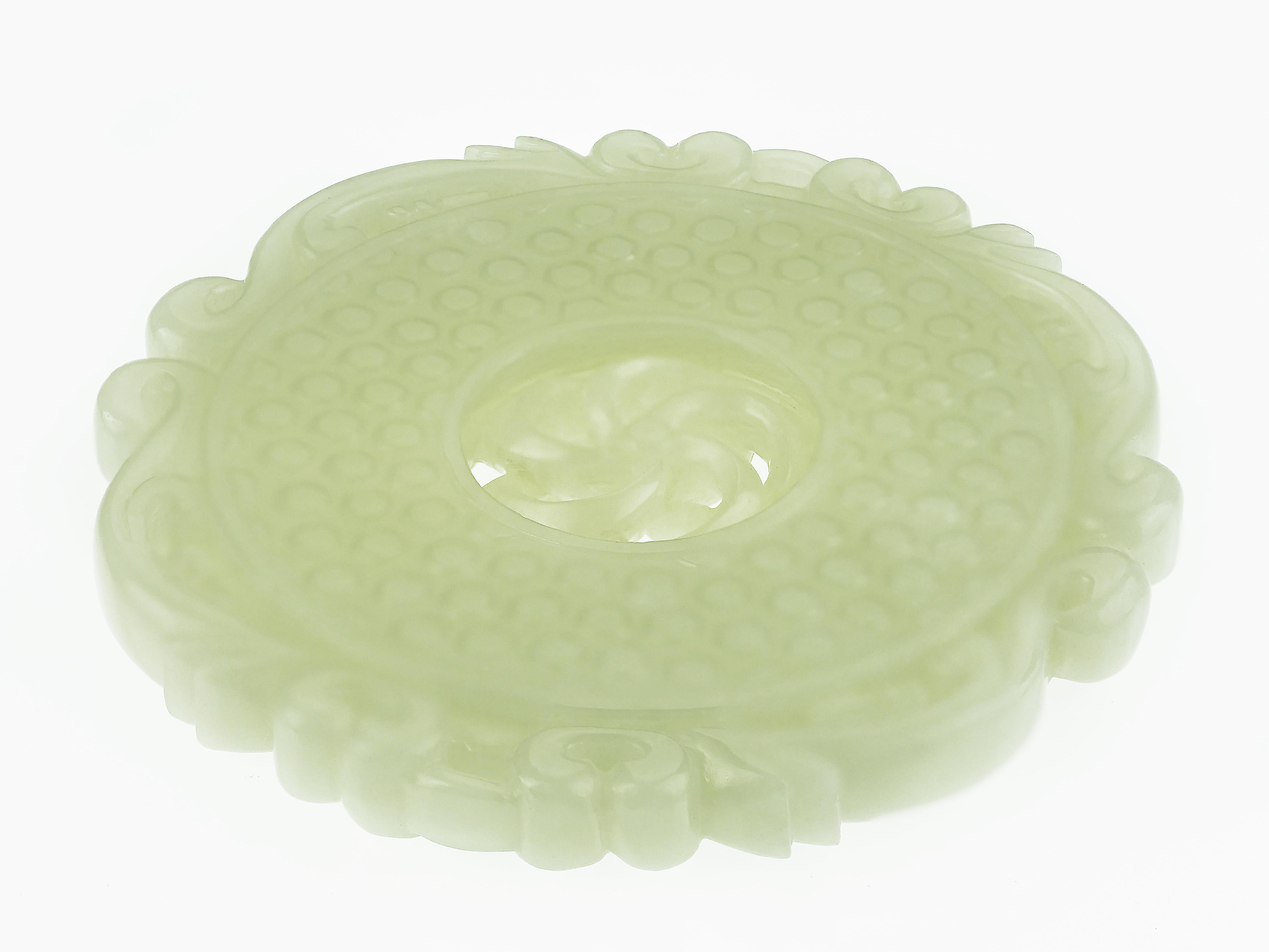 A Chinese carved pale celadon jade plaque, in circular Bi form with dragons surrounding, carved Chi pattern on both sides and pierced free moving flower centre.
Natural Nephrite Jade
Circa 1900
