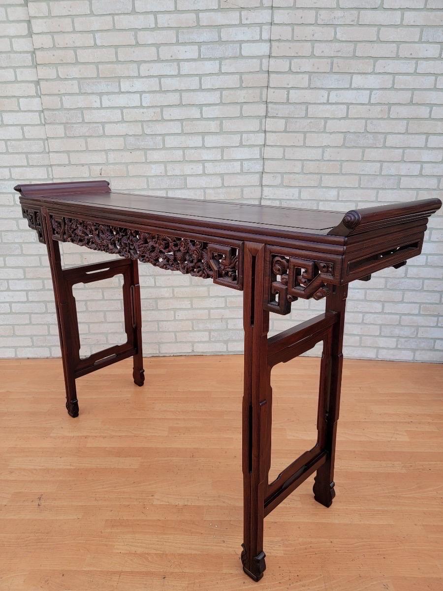 Antique Chinese carved ornate rosewood alter console table
 
Fantastic and radiant grain is featured on the exceptional top panel of this Chinese Huali rosewood table with remarkably straight patterns flanked to beautiful scroll tipped swirls.
