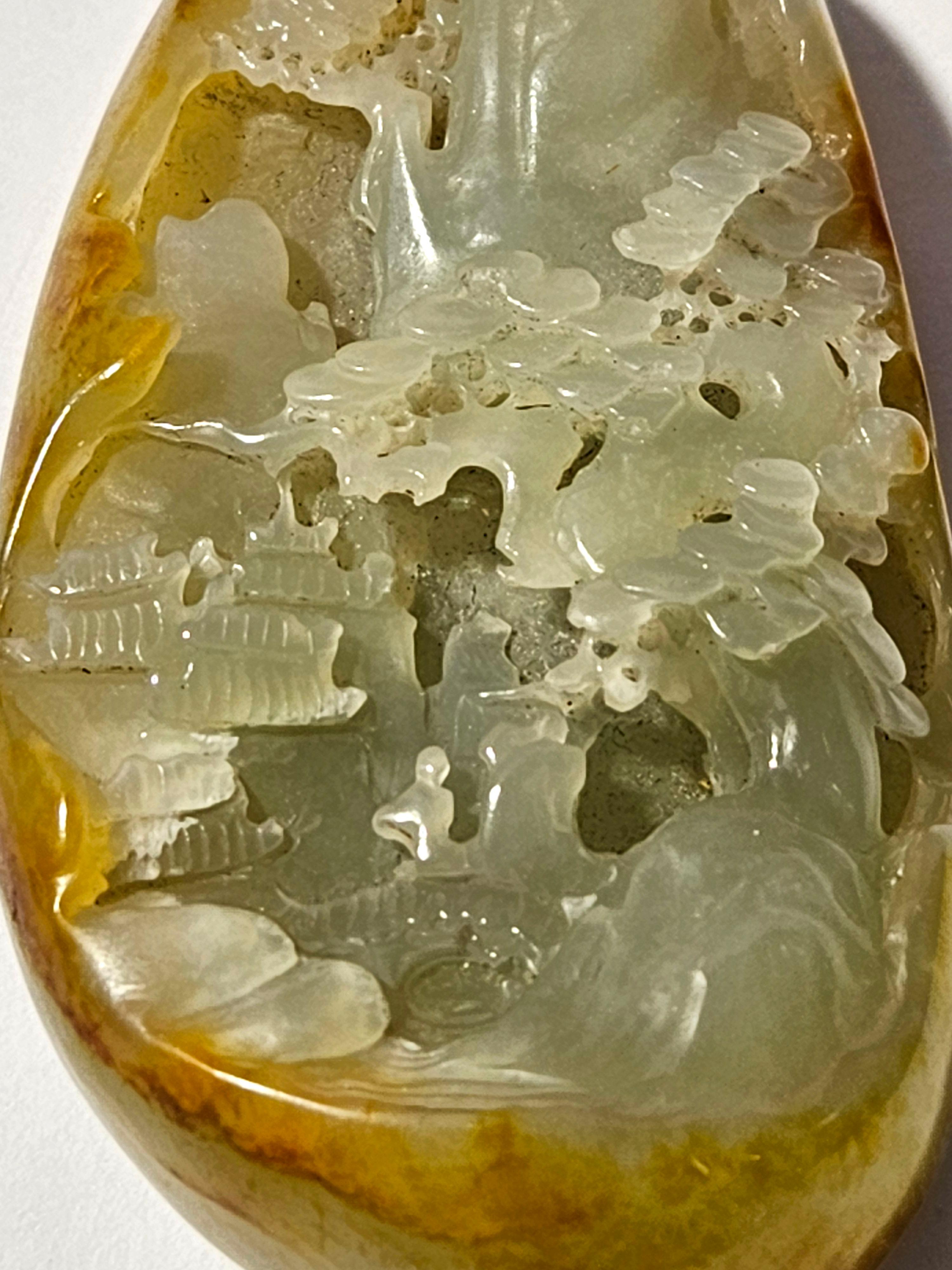 Ancien galet chinois sculpté en jade blanc Hetian avec décor paysager.

La 