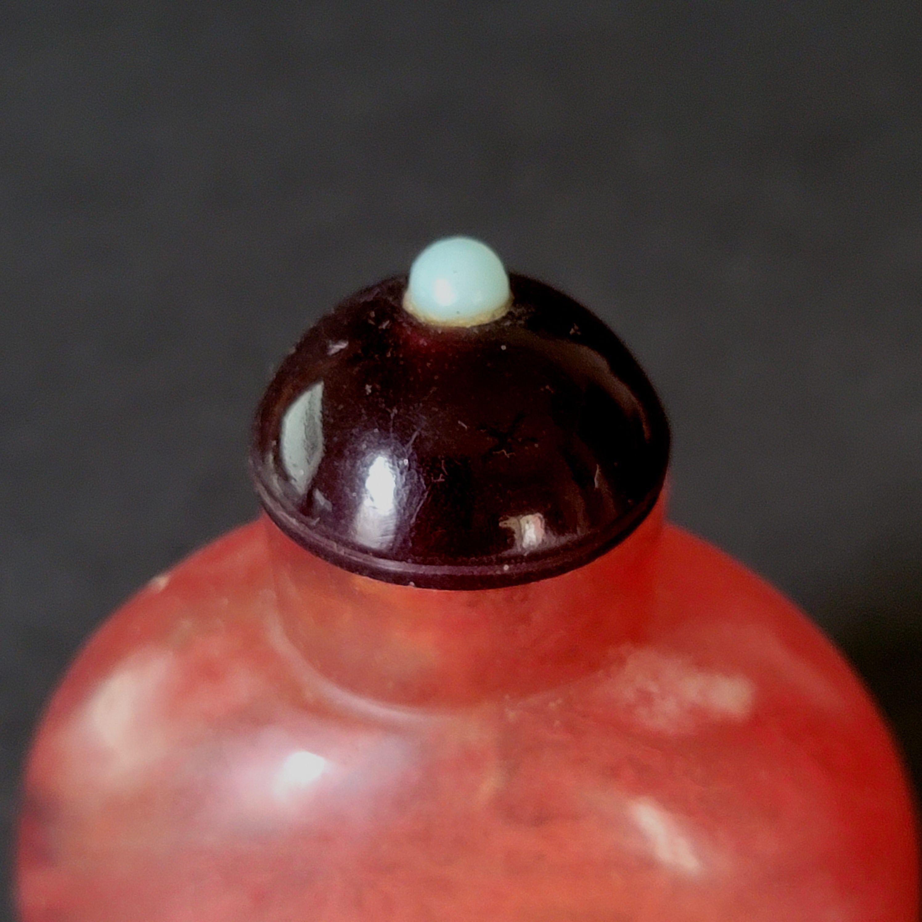 Une belle et fine bouteille à priser en pierre rouge sculptée, un intérieur profondément sculpté avec un bouchon en pierre sombre.
 
