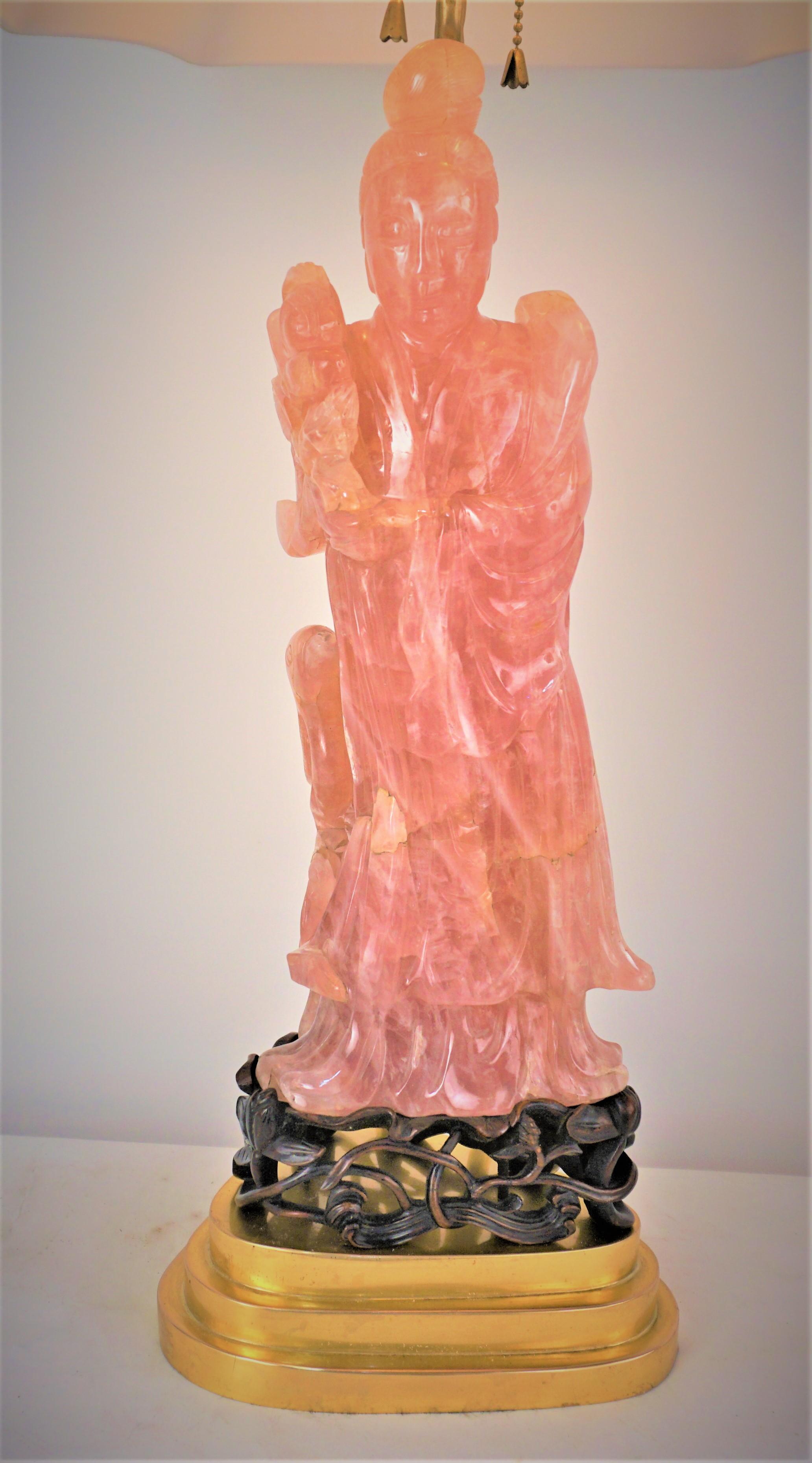 Chinese pink quartz sitting on carved rose wood base.
Customized to a table lamp with gilt bronze base.
Professionally rewired with double sockets.
Measurement includes the lampshade.