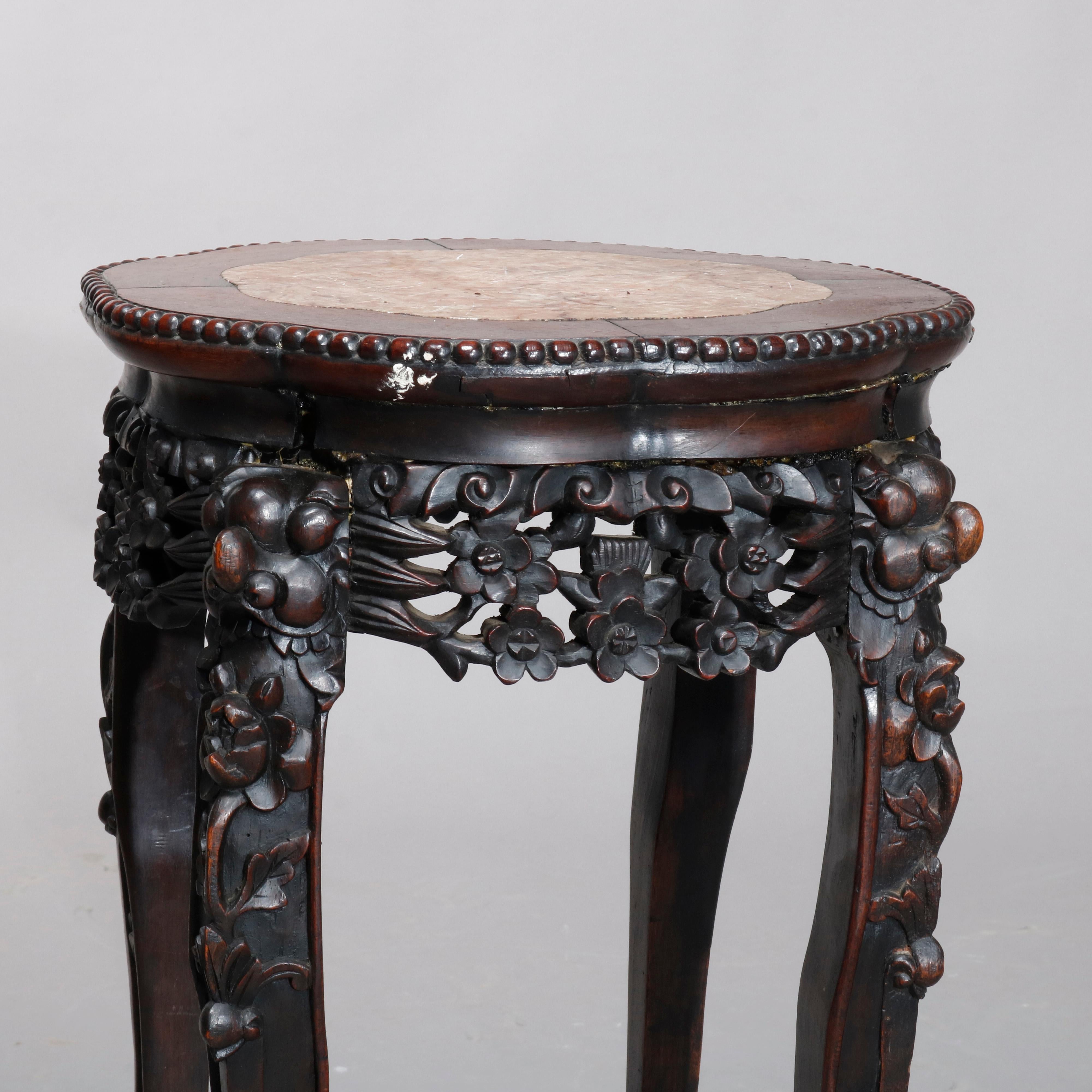 An antique Chinese plant stand offers shaped inset marble-top over carved rosewood stand with pierced floral form skirt, raised on cabriole legs terminating in paw feet, circa 1900

Measures: 27.25