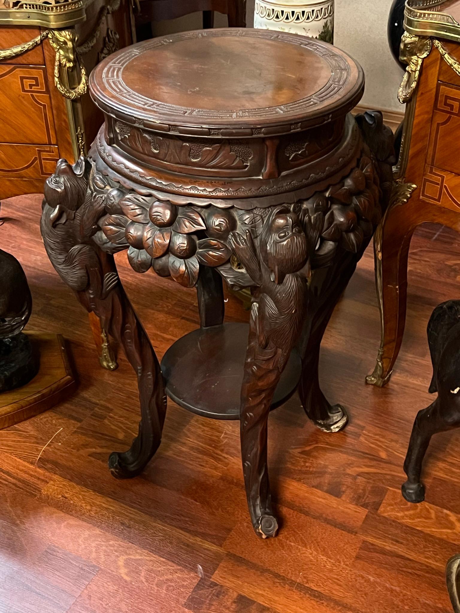 Finely carved antique side table or plant stand depicting monkeys climbing among vines of fruit.  