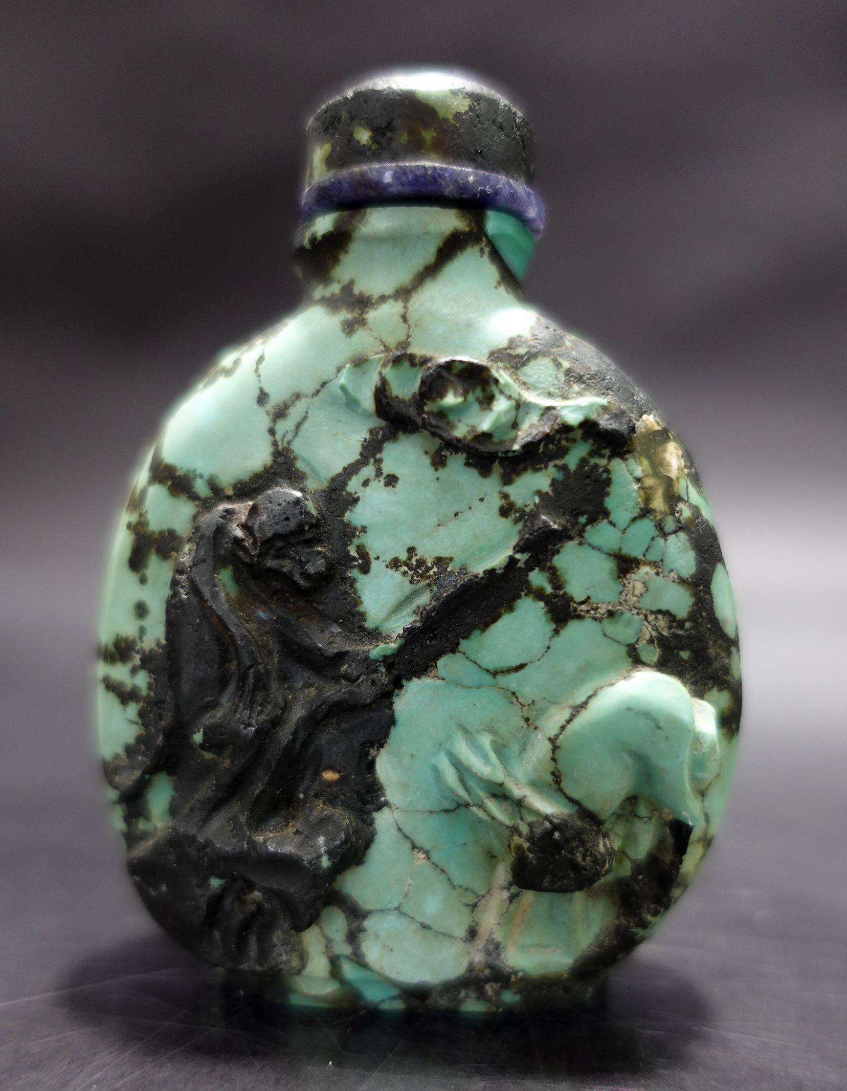 Turquoise snuff bottle. China. 19th century. Tibetan turquoise in hematite matrix. Surface carved with monkeys and mythical animals. Well hollowed. Matching stopper. 2.5in H.
A very unique selection of the highest quality turquoise and heavy feeling