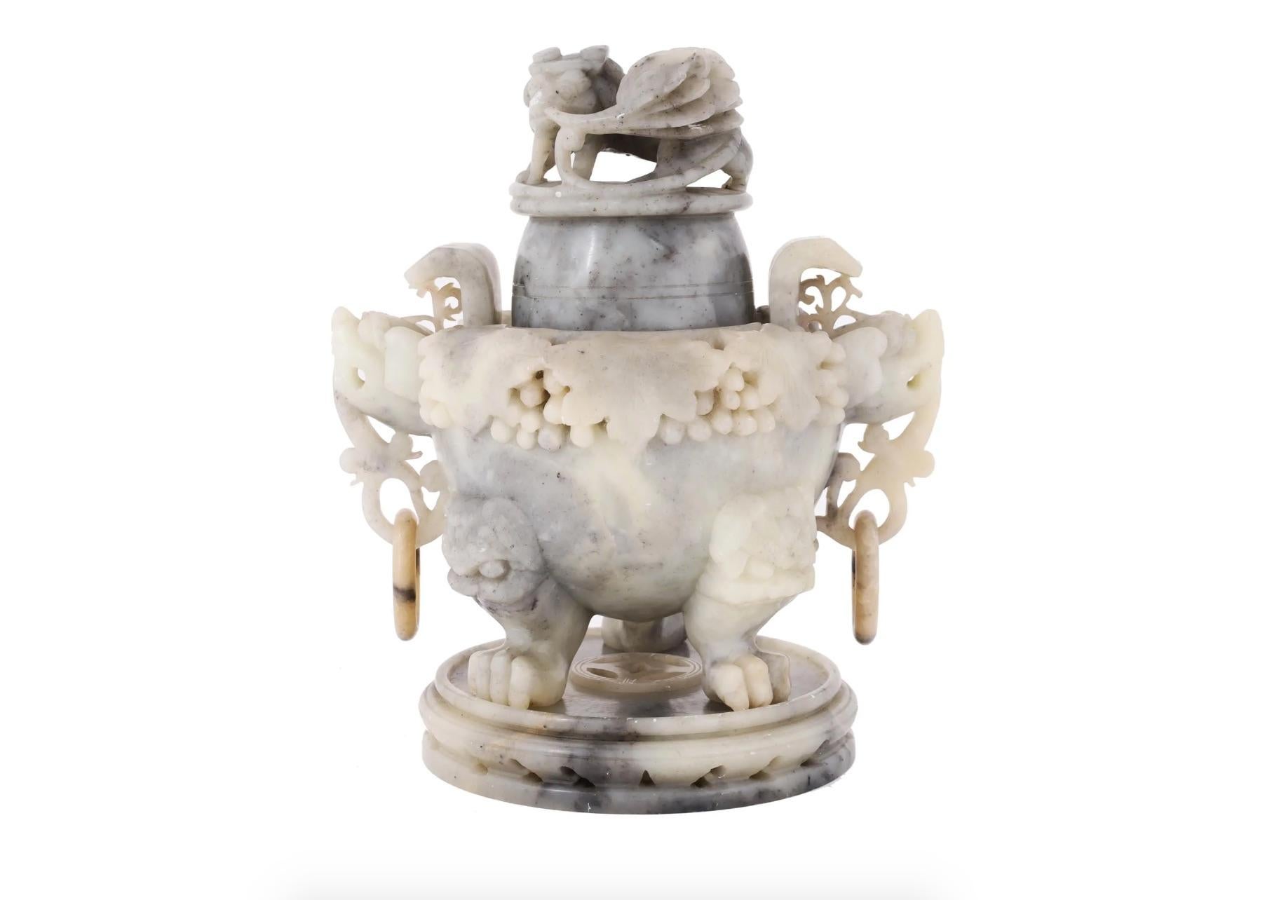 An antique Chinese covered figural hand carved White Jade desk incense burner. The base is adorned with a relief grapevine motif, and mounted on figural legs made in the shape of three paws, a pair of rings on the sides. The finial is adorned with a