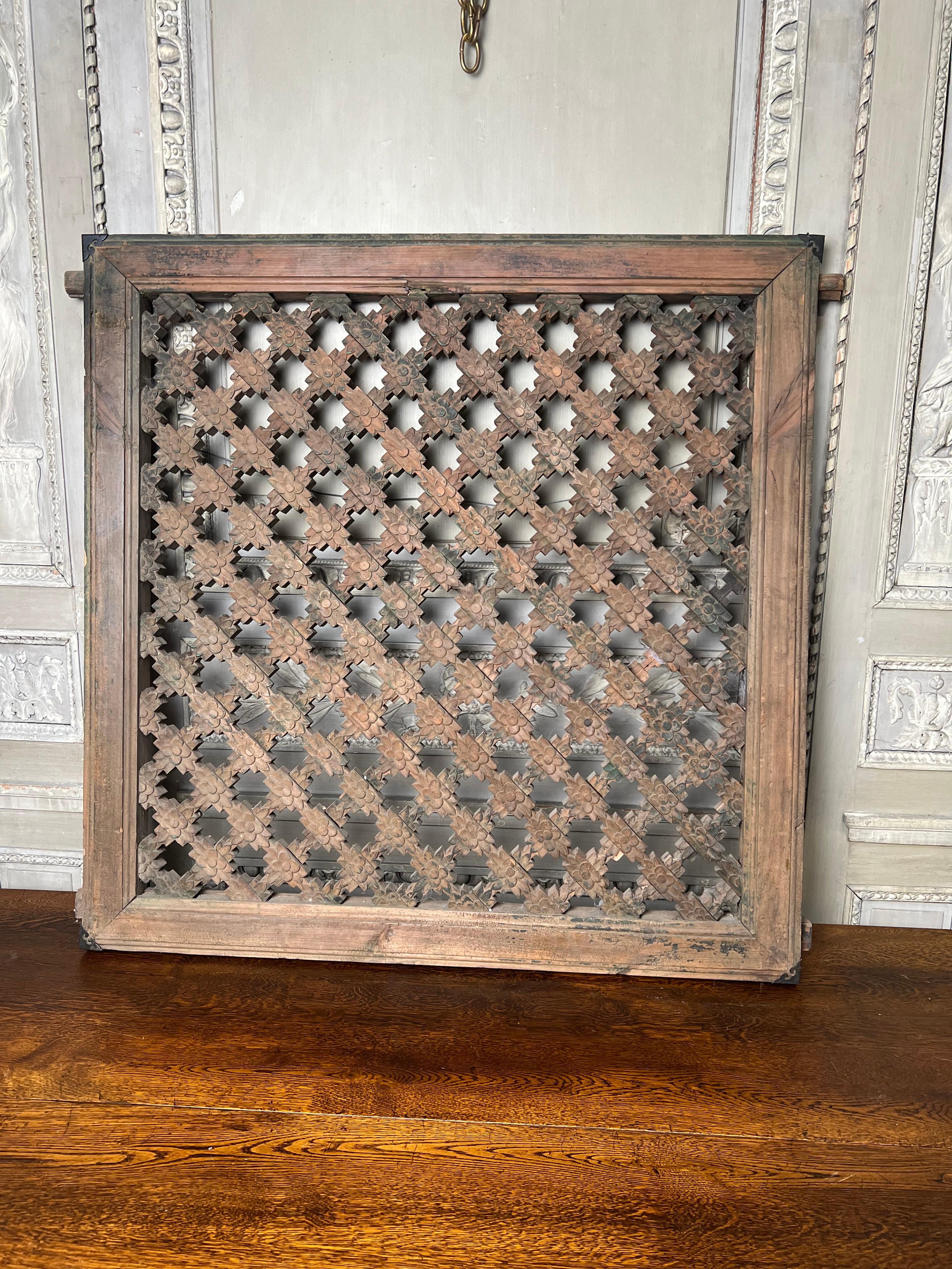 An antique Chinese carved wood window panel with piercing and a geometric pattern.  This very decorative architectural element is a good size and can be used to hand on the wall or inserted into a table base with a glass top.  