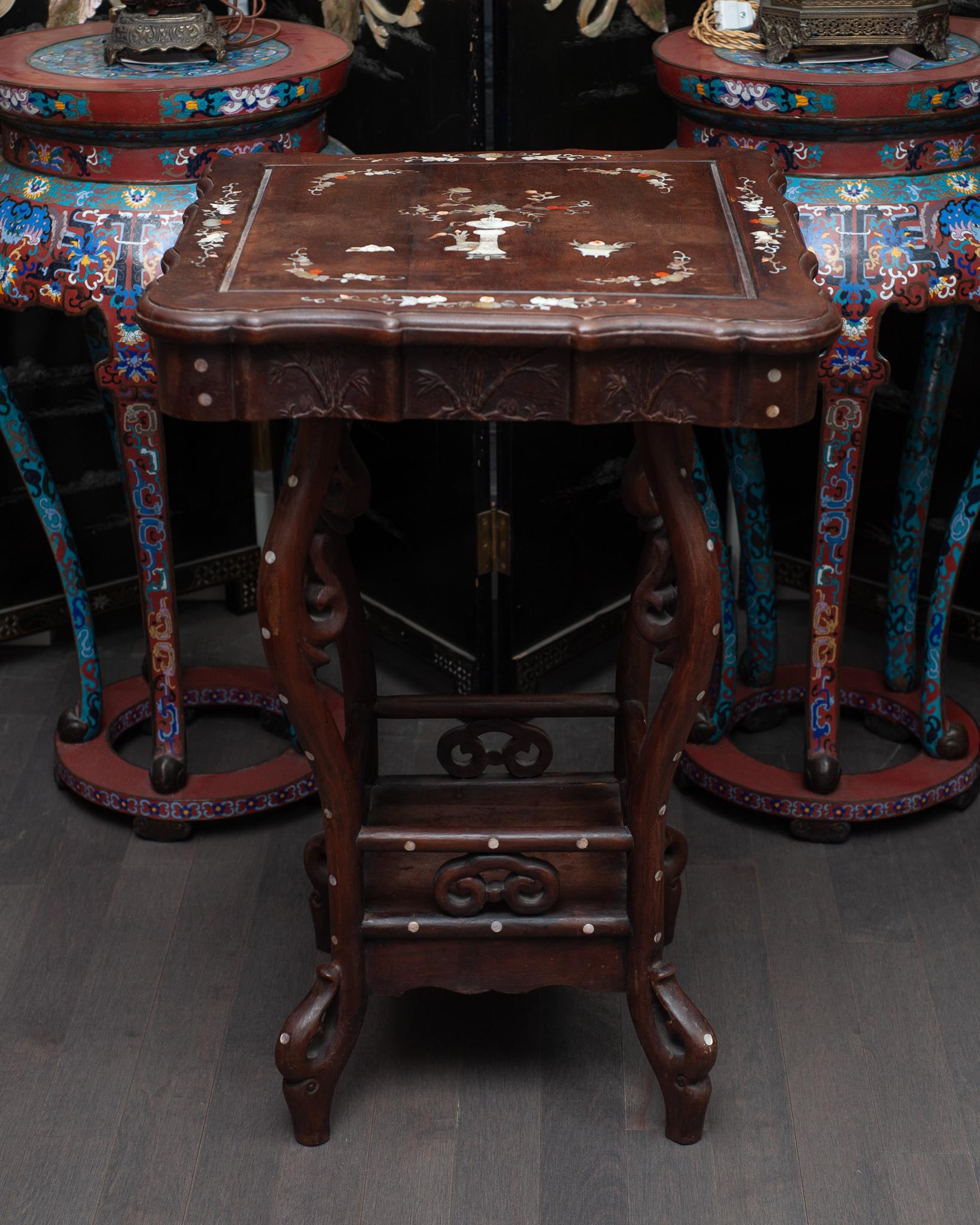An unusual Chinese antique carved wood table with beautiful mother of pearl inlay.