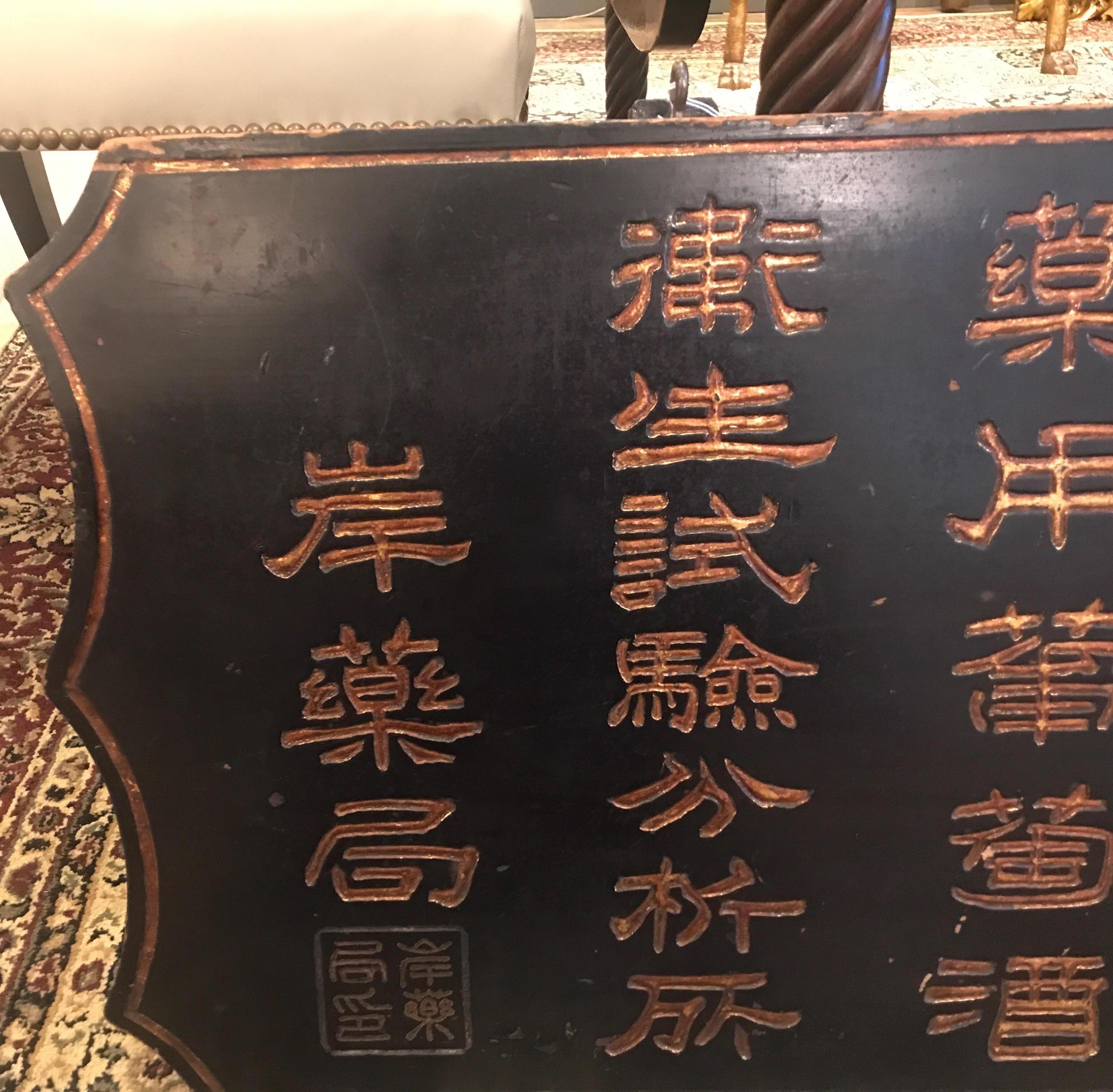 Unique hand carved wood trade sign from China, 1890s. The sign with hand carved Chinese lettering with gilt highlights. The black background with a gilt border.