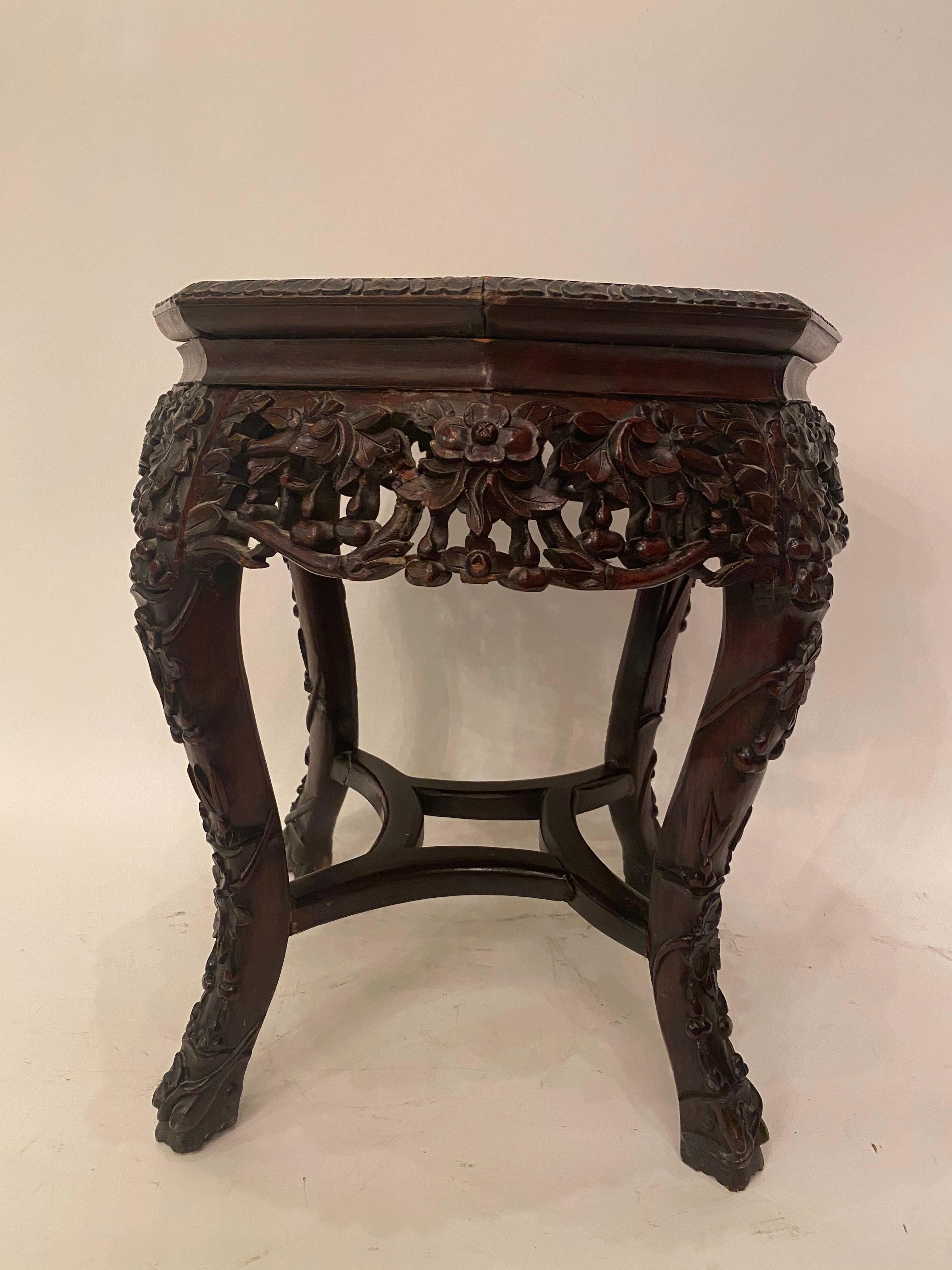 Antique Chinese hardwood carved flowers stands with 8 sides octagonal marble top insert, 19th century. Measures: H 18.625”, D 16.5”.