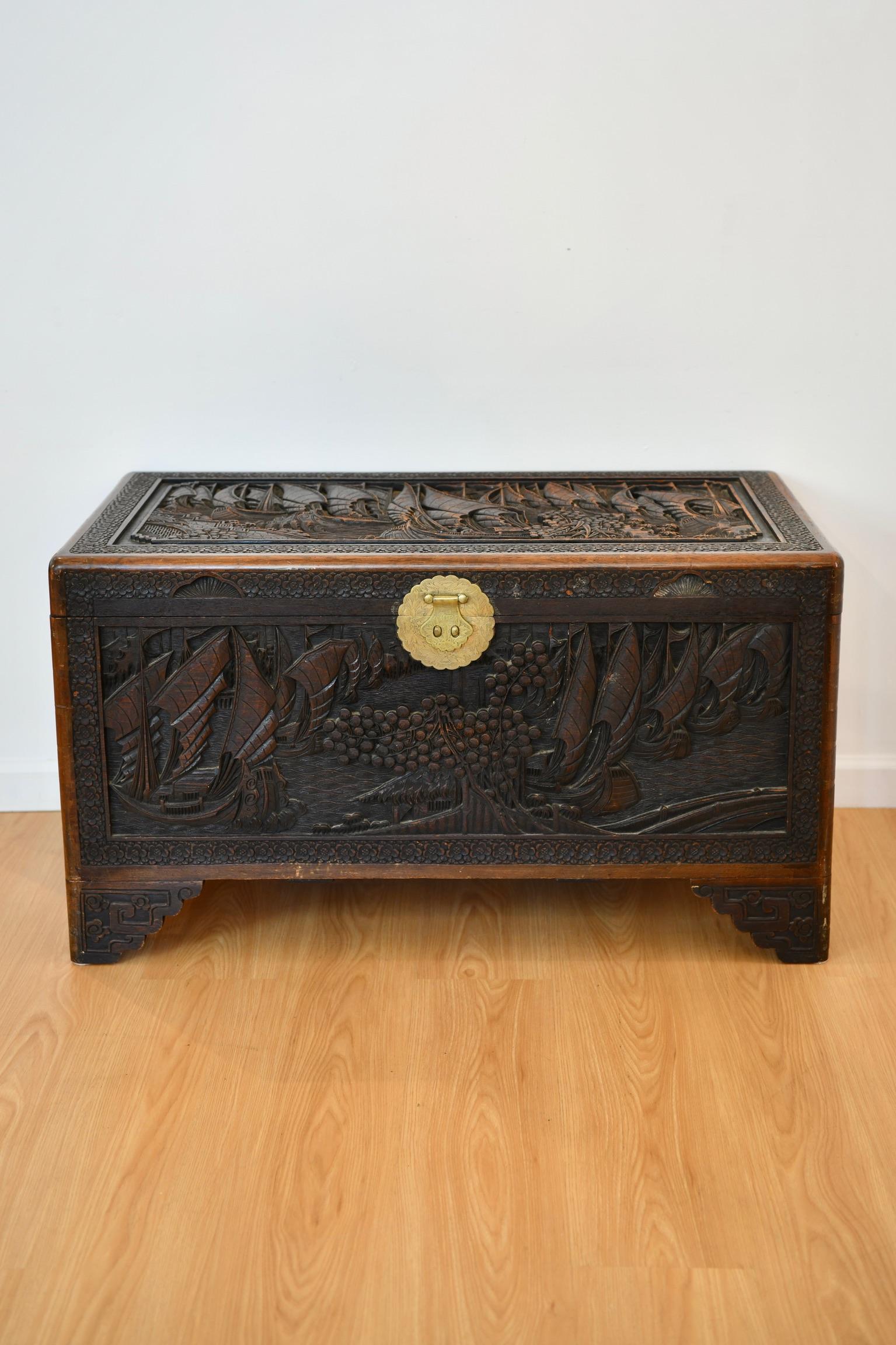 Antique Chinese cedar chest with carvings of sailing vessels and trees, includes internal fitted rack and lock and key. Lock and key not pictured. Dimensions: 22.5