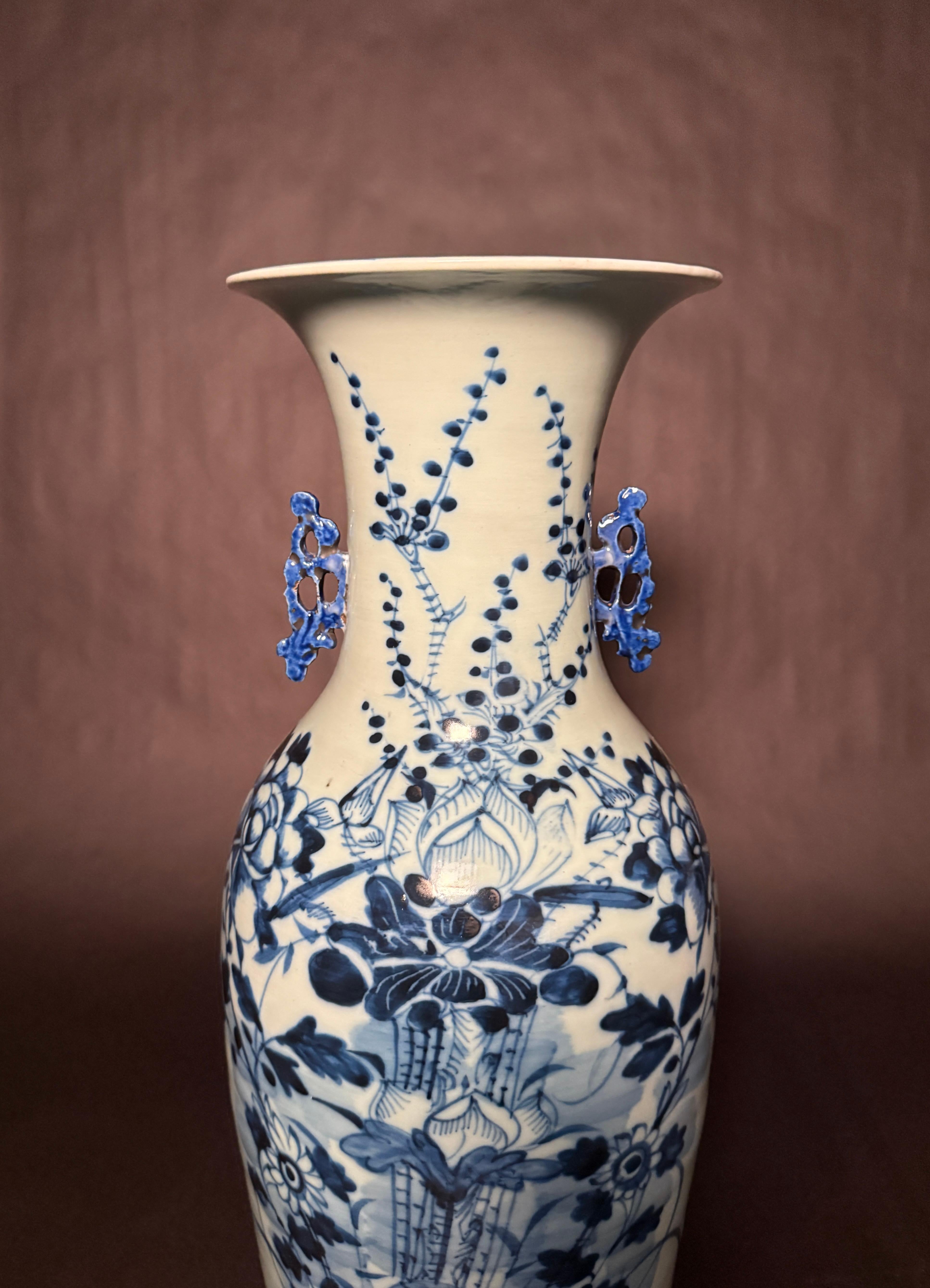 A large antique 19th century Chinese floor vase having a celadon ground and blue and white underglaze decoration to the body. The underglaze decoration is of  foliage, stems with berries, fruit and flowers. Painted decoration to the top rim. Applied