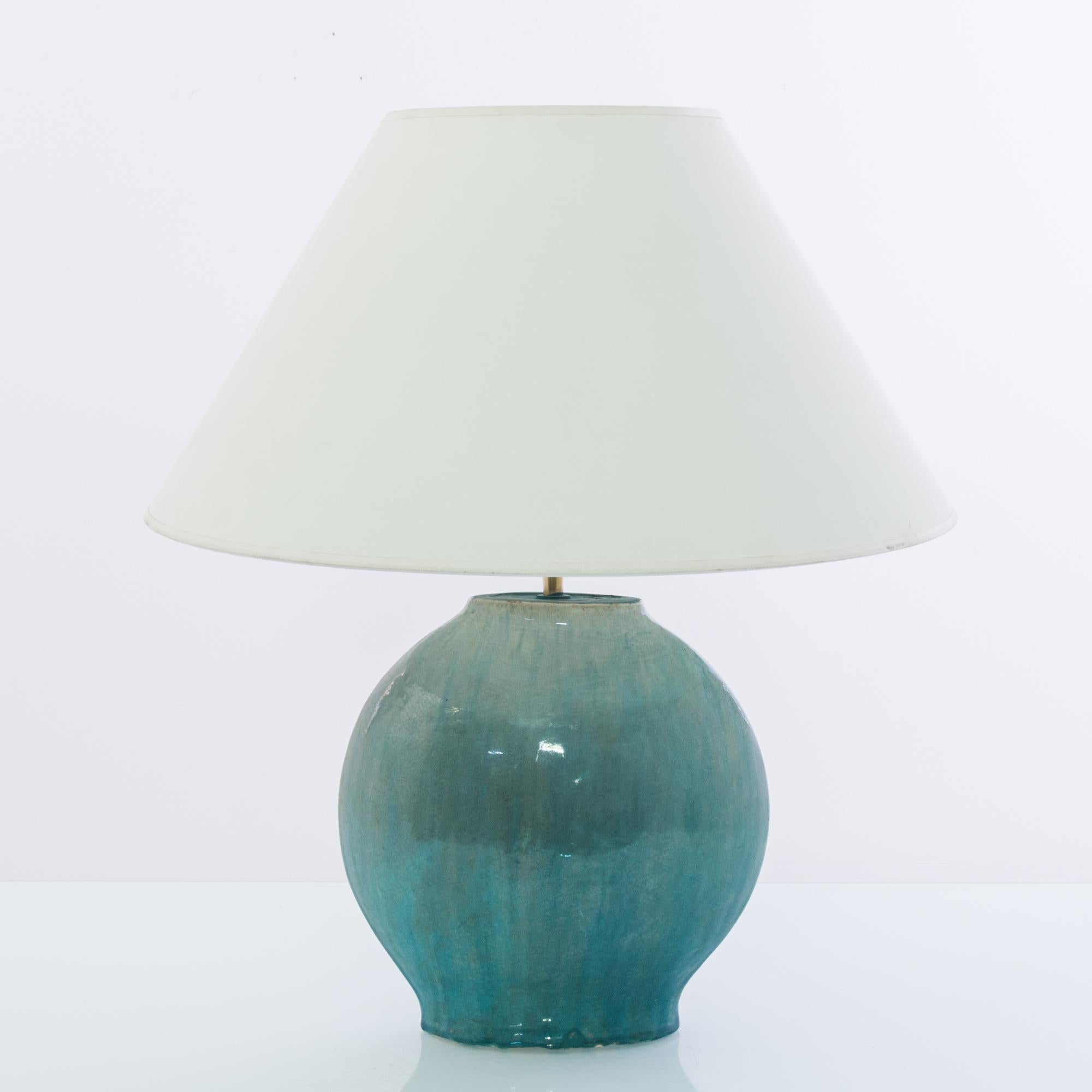 A vintage Chinese vase, fitted with an adjustable brass fixture and E26 lighting socket. The gradated celadon green glaze creates a vivid visual impact. Textured glazes, attractive colors and organic shape grants a sensuous tactility to the form.