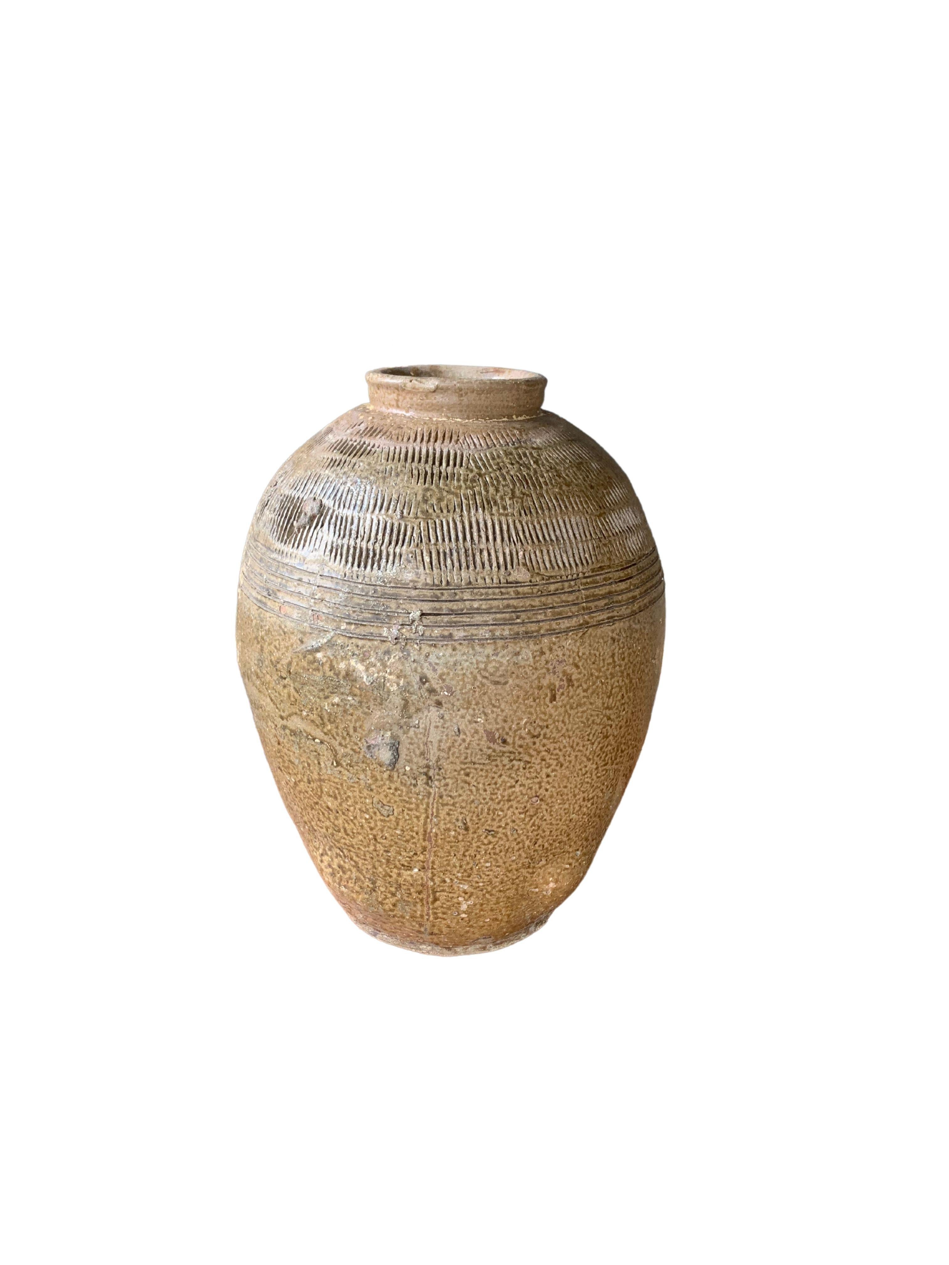 Questo vaso in ceramica cinese smaltata, risalente all'inizio del XIX secolo, veniva usato un tempo per mettere in salamoia gli alimenti. Presenta una finitura verde giada e una superficie esterna con una texture a coste. Un grande esempio di