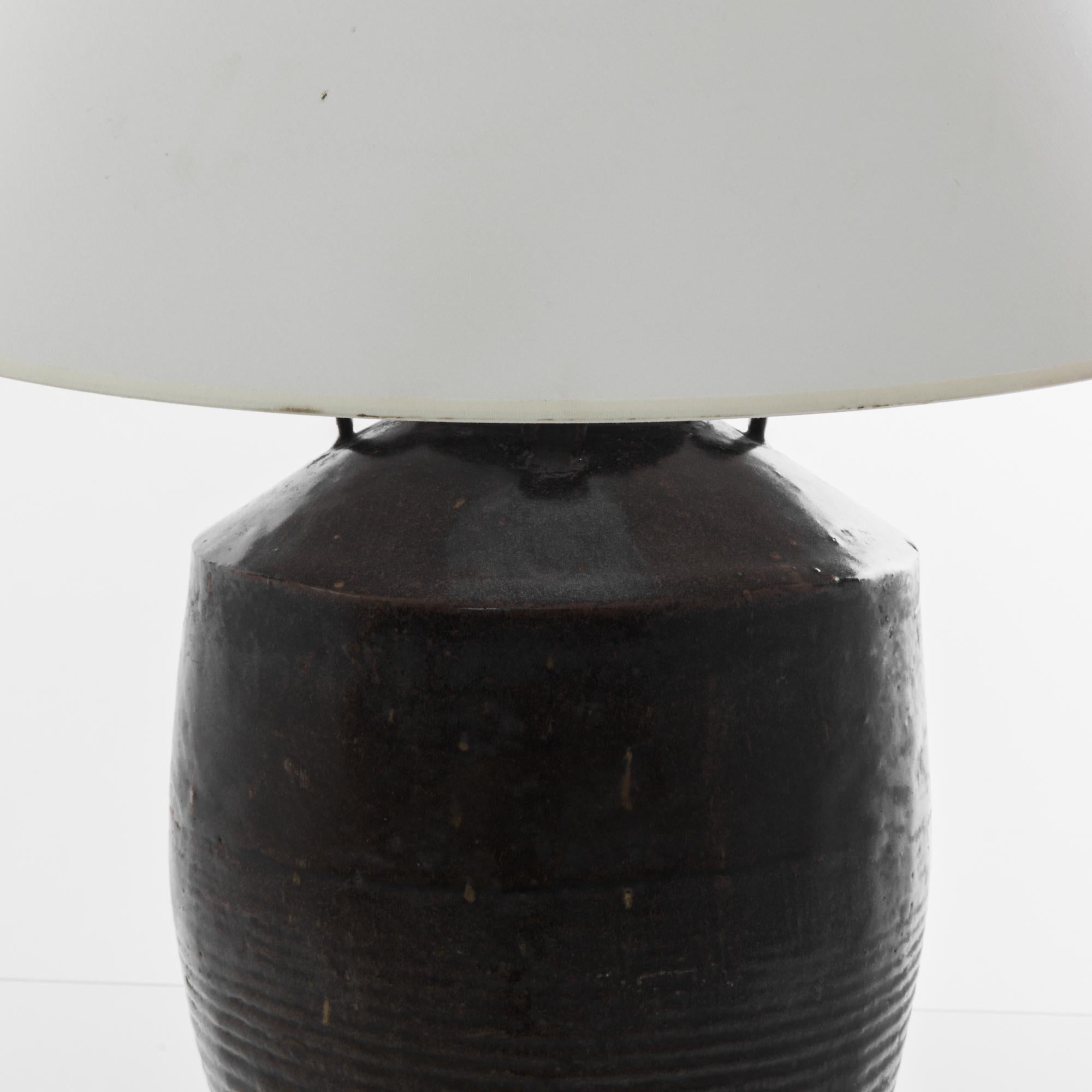 A vintage Chinese vase, fitted with an adjustable brass fixture and E26 lighting socket. The deep tone of the earthy black glaze creates a vivid visual impact. Textured glazes, attractive colors and rippling pattern grants a sensuous tactility to