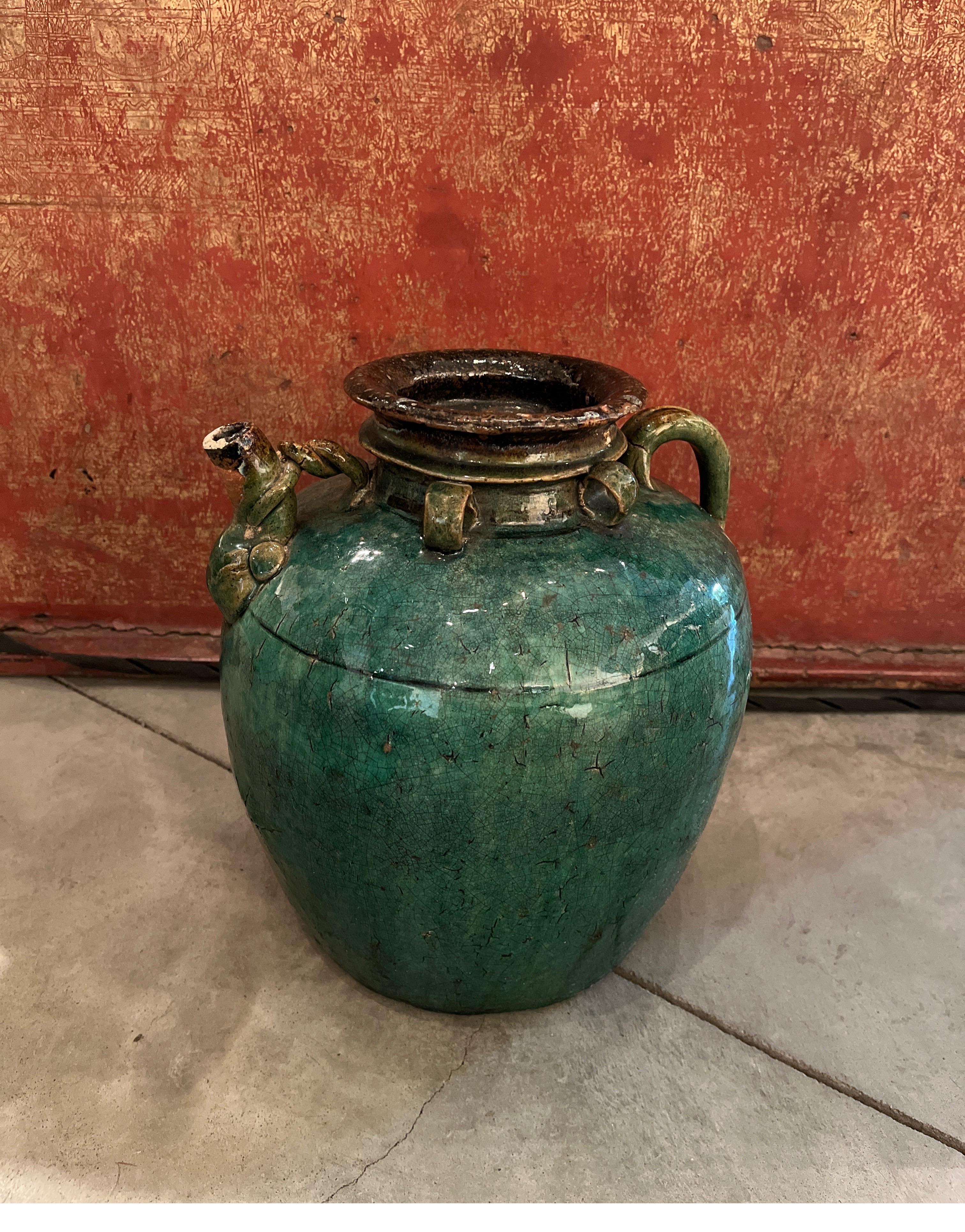 A gracefully shaped, antique Chinese ceramic wine vessel, with a gorgeous green glaze and a great patina produced during well over 100 years of use. An unusual and useful piece that provides striking visual interest, due to it's arresting color and