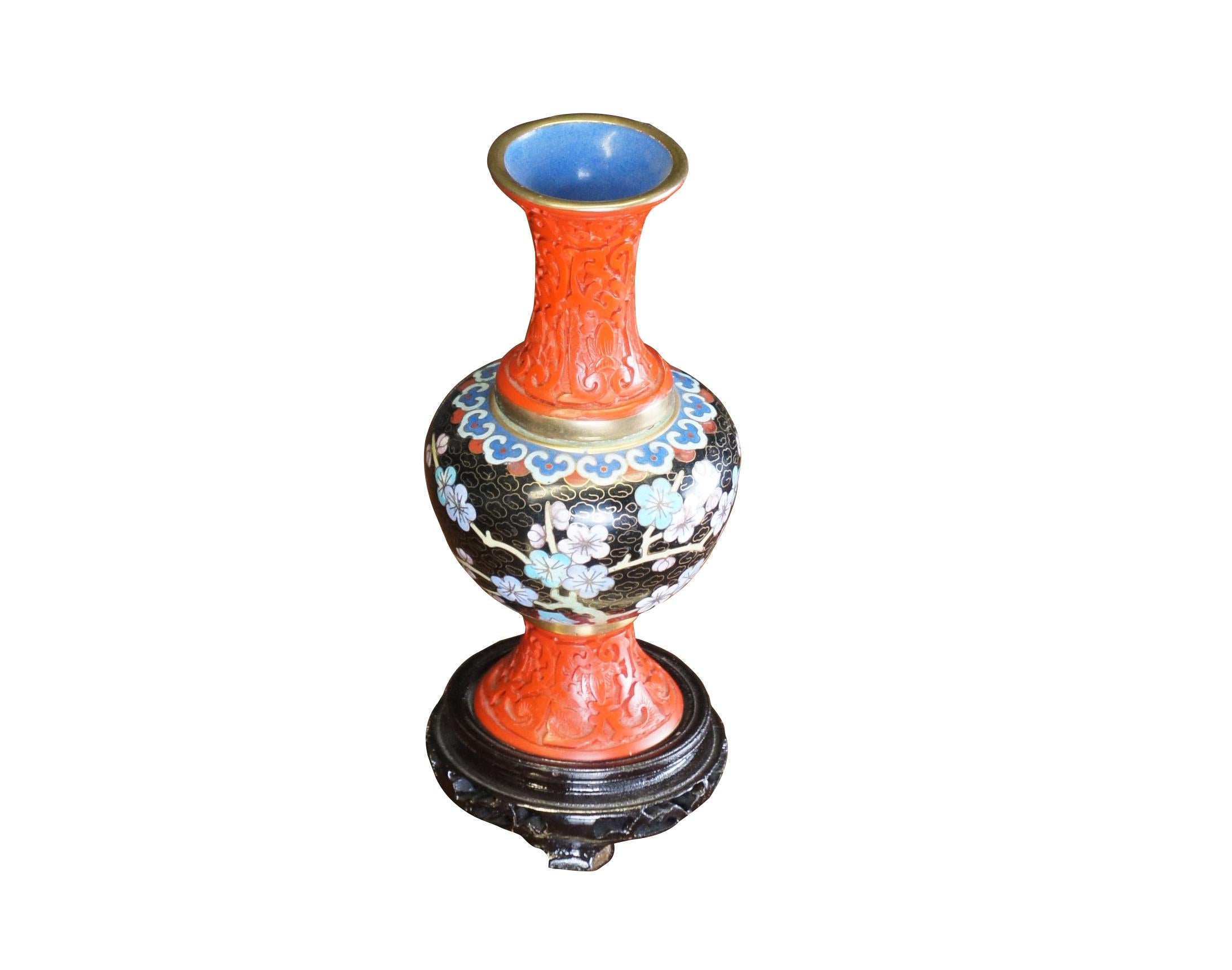 Antike chinesische Chinoiserie-Vase mit geschnitztem Zinnober mit Messingakzenten und emaillierten Kirschblüten auf einem Feld aus schwarzen Wolken.  Inklusive Standfuß.

Abmessungen: 
7