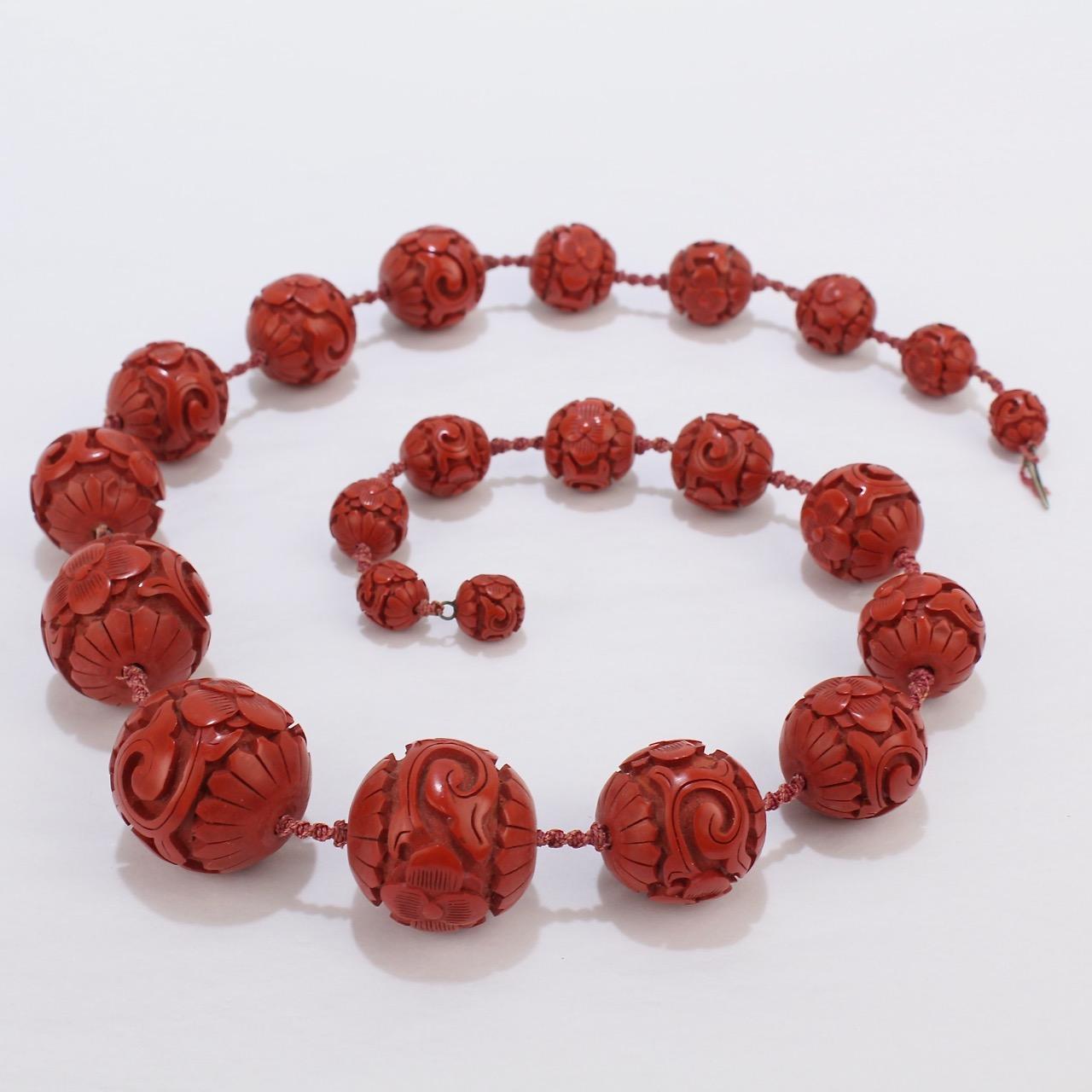 A rare and fine Chinese cinnabar graduated beaded necklace.

Found in a Boston estate. By repute, the necklace was purchased with numerous other Chinese items in the 1920s.

The beads range from 11 mm to 29 mm in diameter and are strung on an