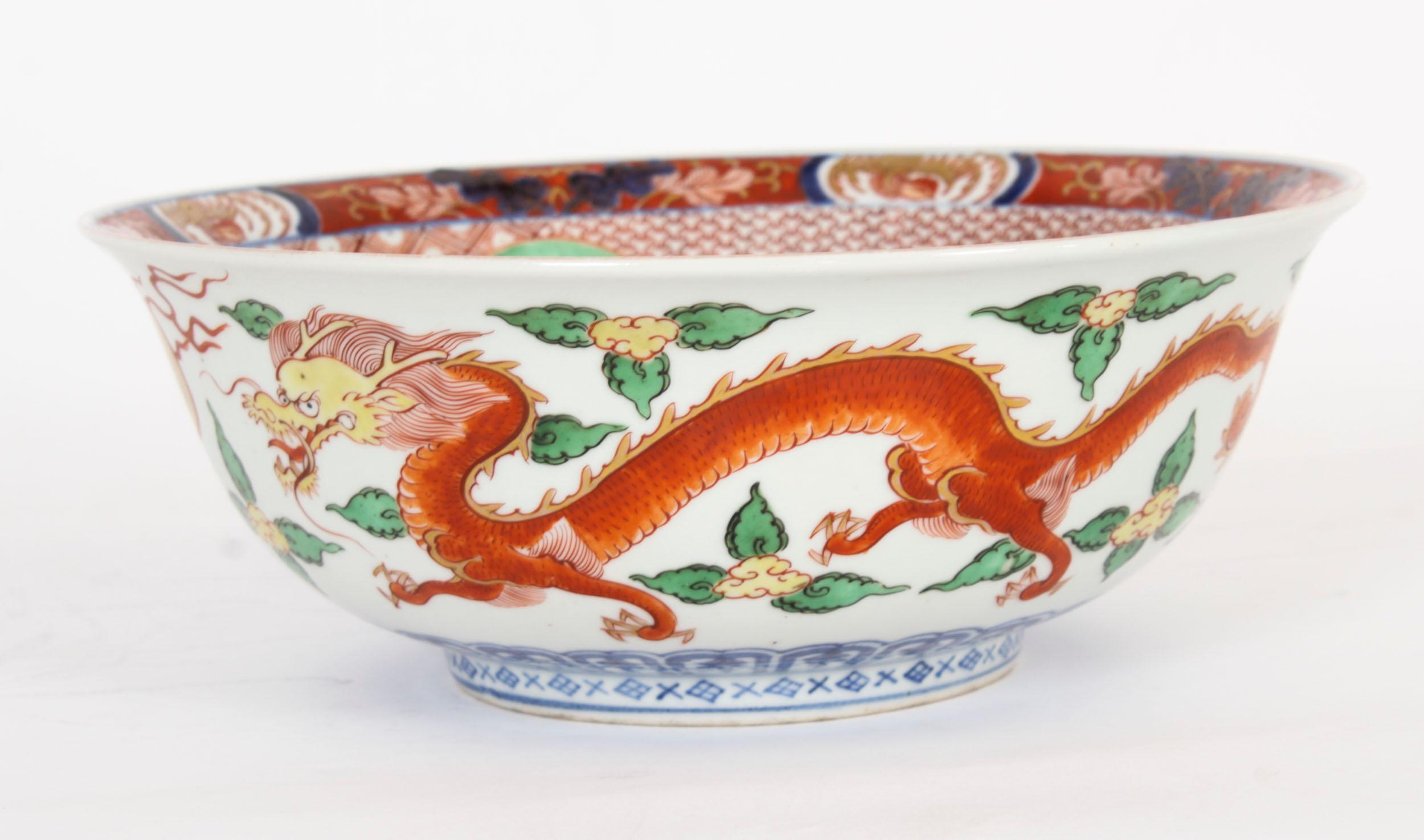 A large beautiful Chinese export porcelain centre bowl, dating from circa 1890.

The circular bowl is in the Imari palette and features enamelled decoration with panels of dragons, kylins, bats and phoenix within key fret and dense foliate borders