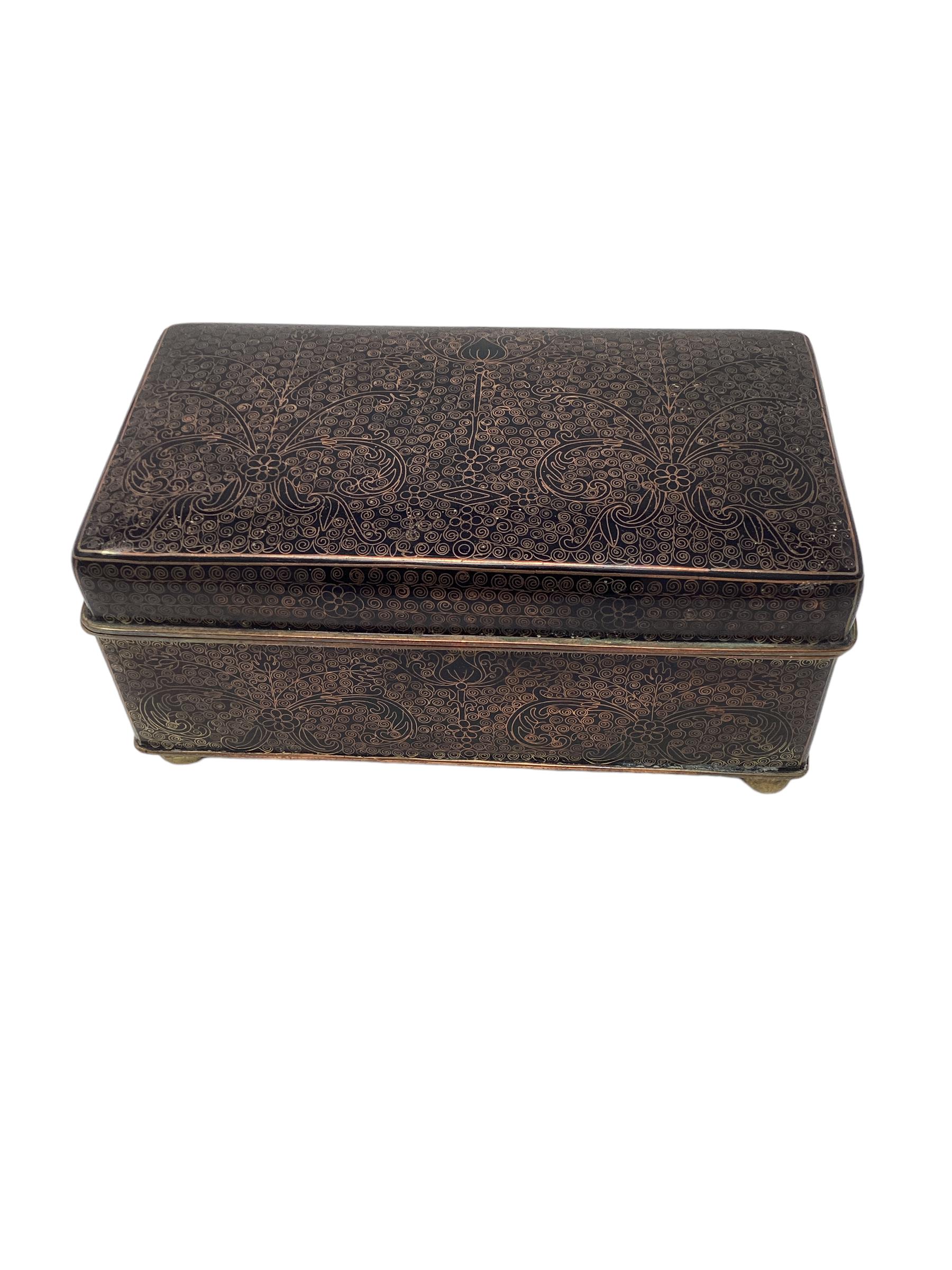 Ancienne boîte cloisonnée chinoise avec intérieur en bois. La boîte repose sur des pieds ronds en laiton. L'intérieur semble avoir eu des séparateurs qui ne sont plus dans la boîte.