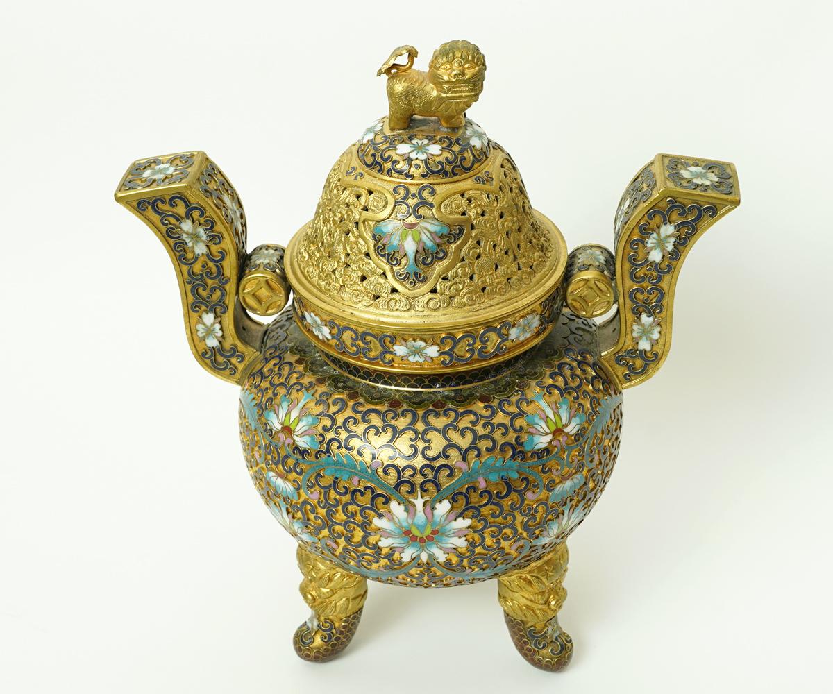 Chinese cloisonné censer with foo dogs supporting the three legs and a gilt lion doubling as the lid handle. The top has intricate open work. The primary color is the gold gilt and it has black, turquoise, red and blue accents. Just marvelous