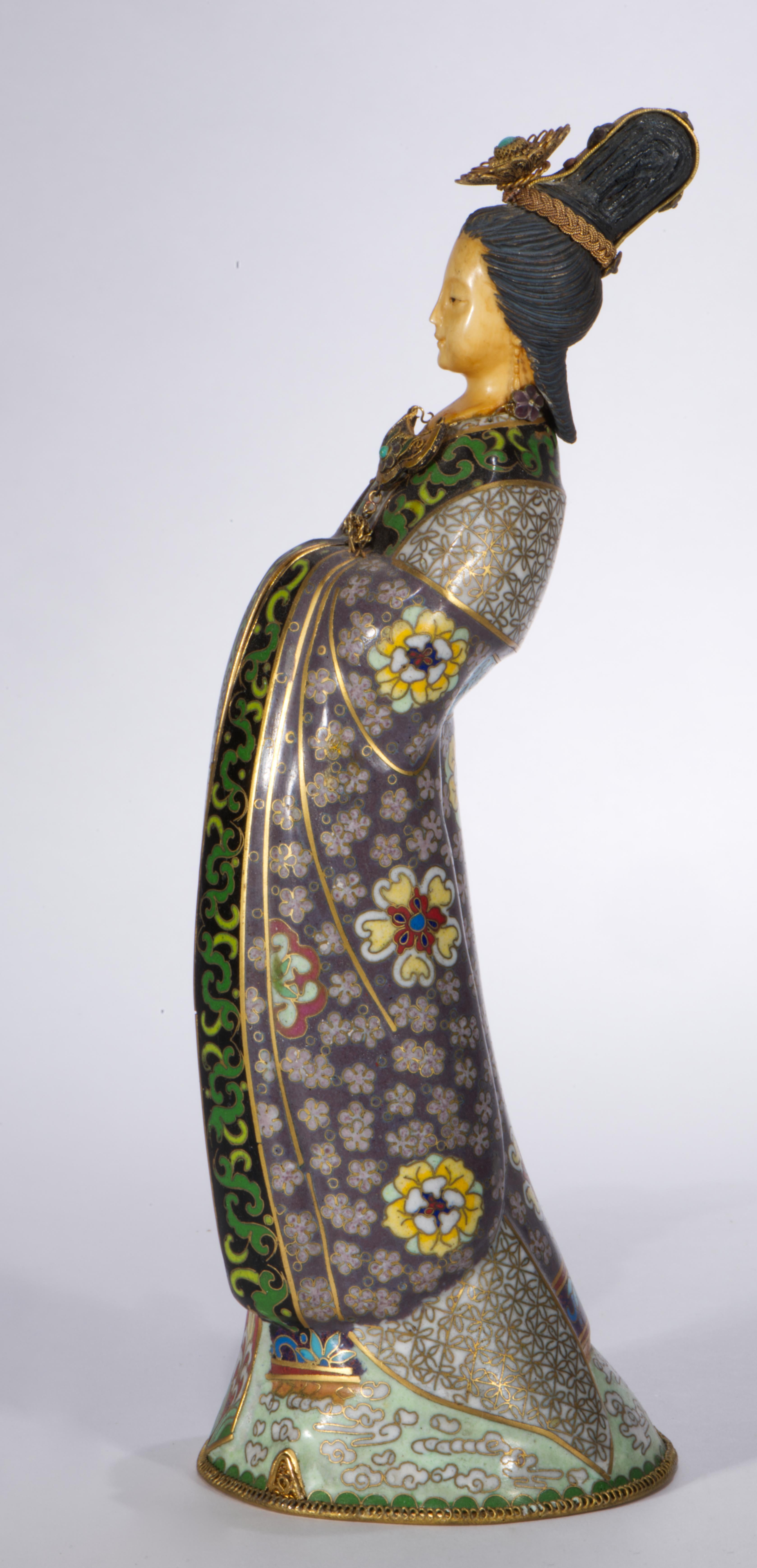 L'antica scultura o statuetta cinese di Guanyin, o Quan Yin, smaltata e intagliata a cloisonné, presenta viso e capelli intagliati e un abito smaltato multicolore finemente dettagliato. I capelli sono adornati con ornamenti in filigrana e le punte