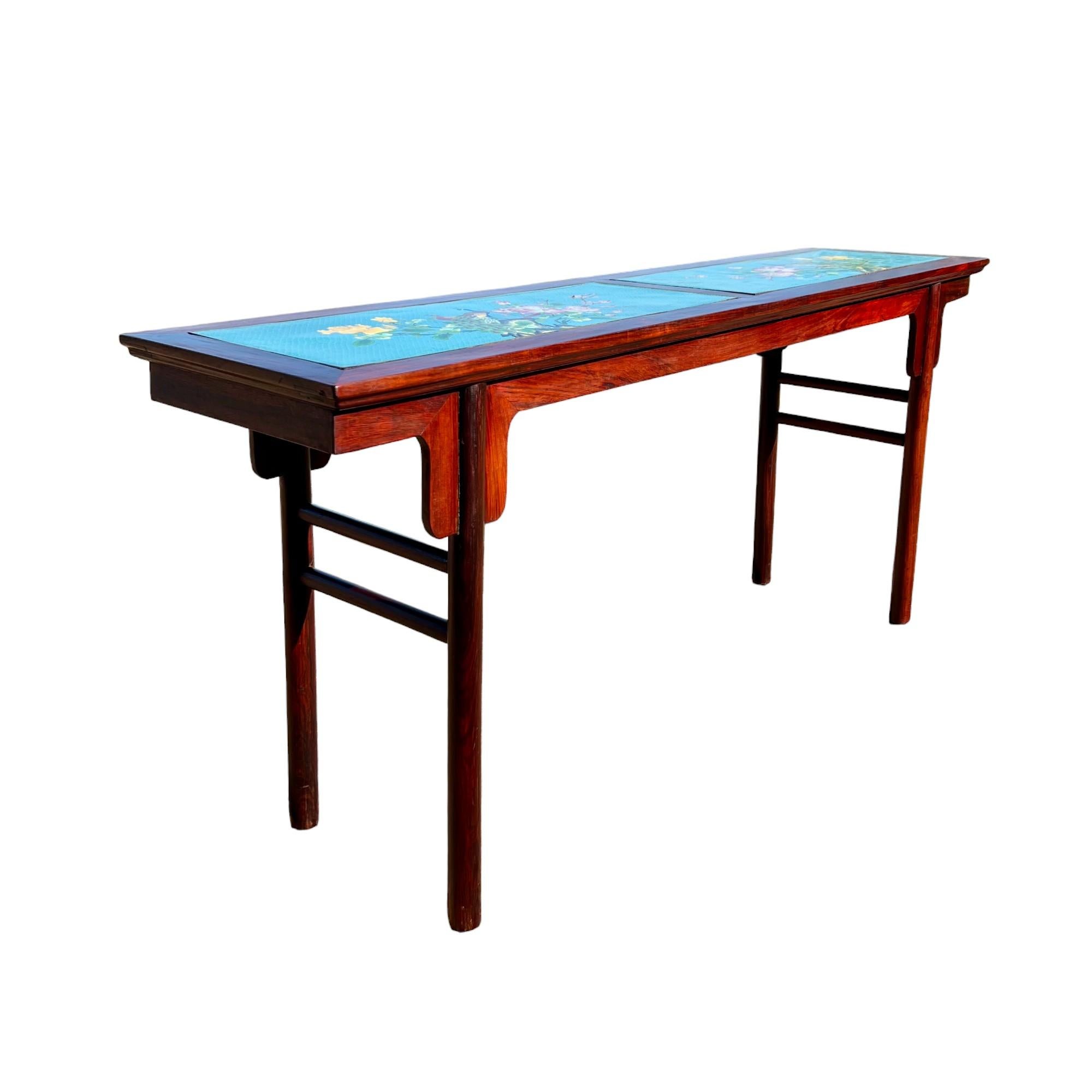 An exquisite antique Chinese Qing dynasty hardwood offering table with cloisonné top, circa late 19th to early 20th century. The modern form of the rosewood frame features a decorative carved apron and cylindrical post legs connected on side ends by