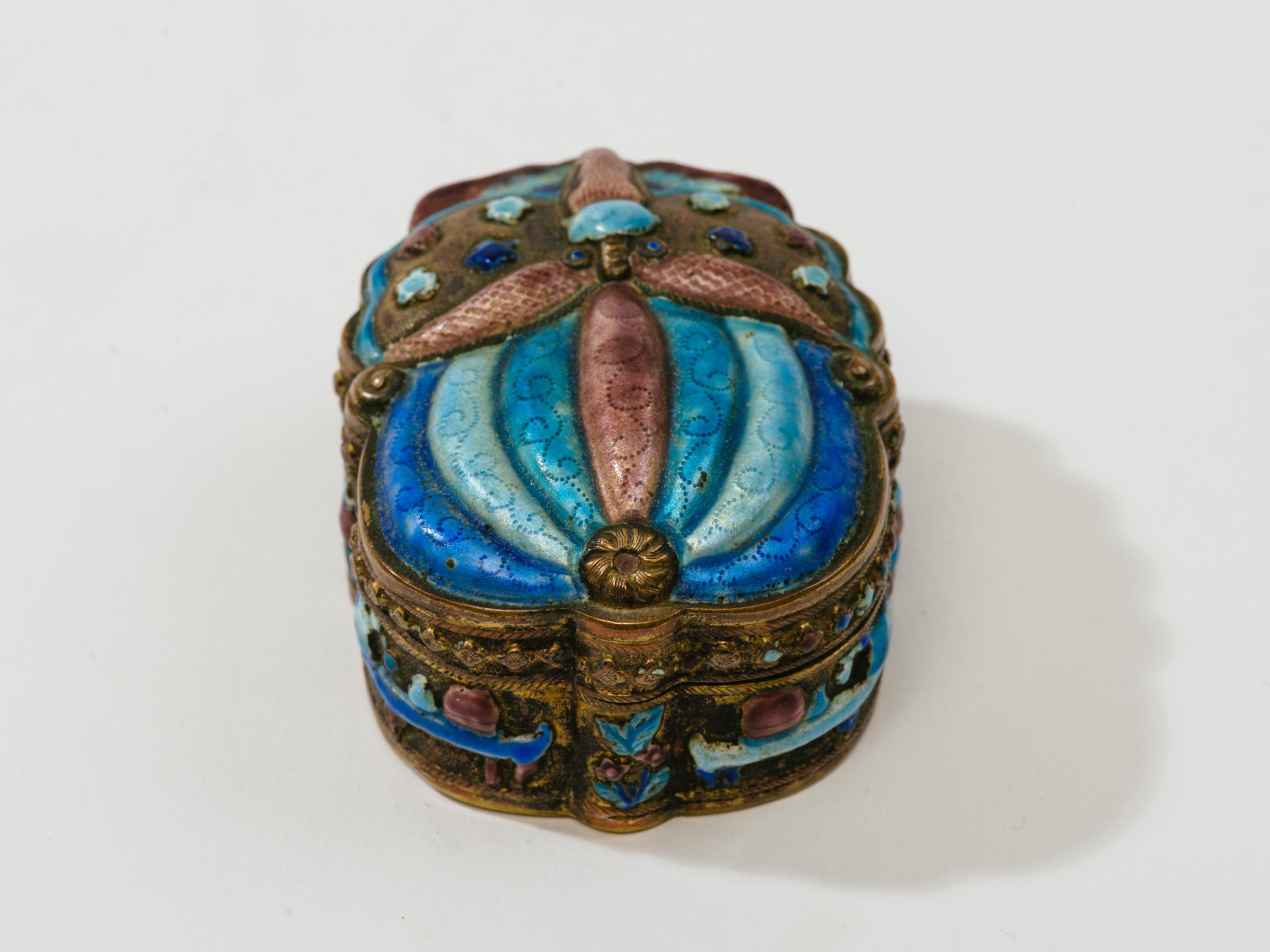Boîte en forme de scarabée champlevé finement détaillée avec intérieur lavé à la dorure. Traces de miroir ancien sur le dessus intérieur. De riches couleurs de bleu, de turquoise et de violet finement émaillées tout autour de la boîte.