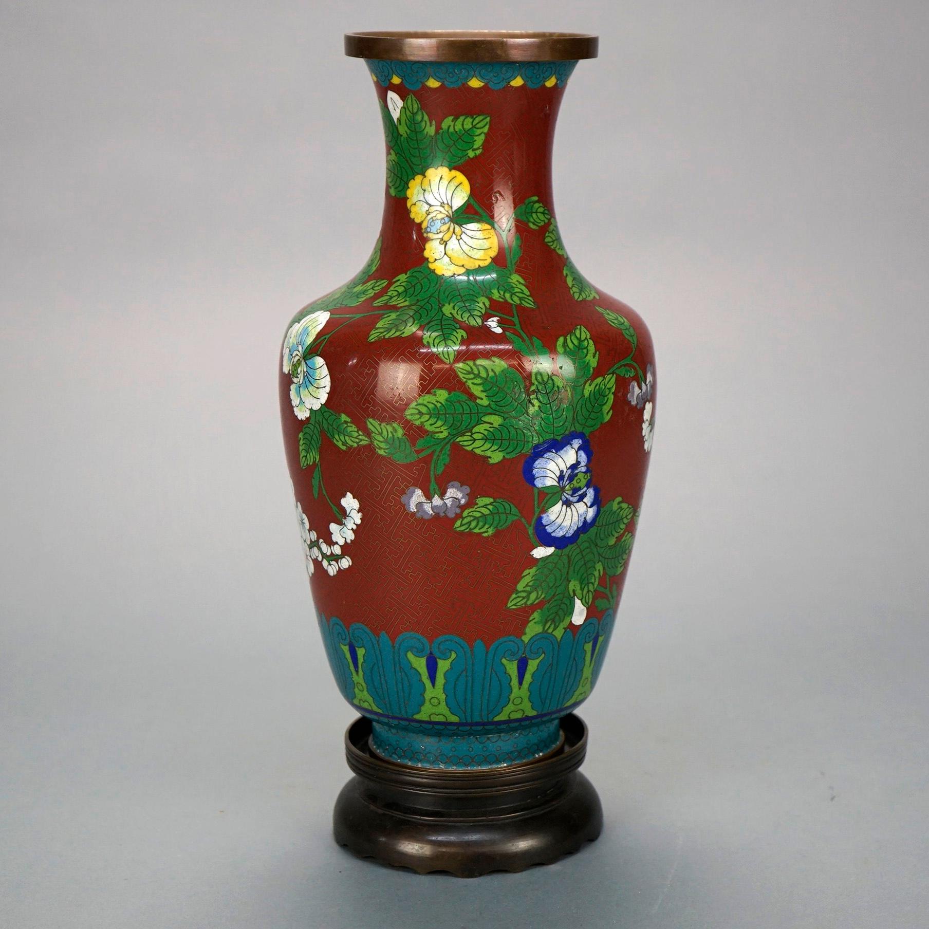 An antique Chinese vase offers Cloissone enameled design in garden theme with flowers throughout, seated on bronze base, c1900.

Measures- Vase 12.5''H; Base 1.75''H; Overall 14''H x 6.25''W x 6.25''D