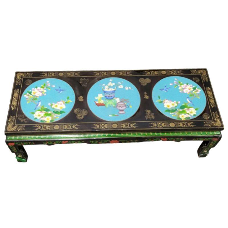A black Chinese coffee table painted with three large blue medallions on top and decorated on all sides with colorful flowers, vines, birds and vases. The table top is decorated with a gilt border and gilt detail around the medallions. The apron,