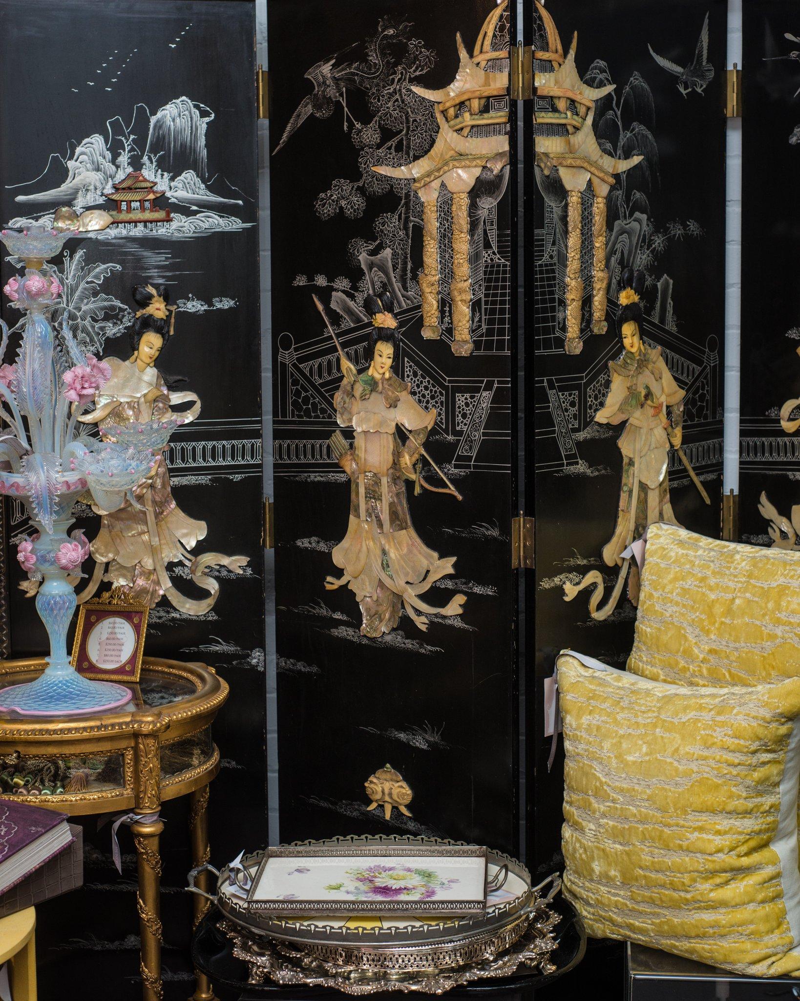 This antique Chinese screen features intricate inlaid mother of pearl goddesses. What makes this screen unusual is the grand scale of the design of the figures. The screen is lacquered in black and entirely hand painted. The reverse side of the