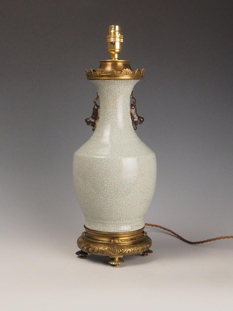 Antique Late 19th Century Chinese Crackle Glaze Table Lamp with Foo Dog Motifs and Ornate Bronze Mounts
A captivating Antique Chinese Table Lamp, dating to the late 19th century, expertly combining traditional Chinese ceramic artistry with fine