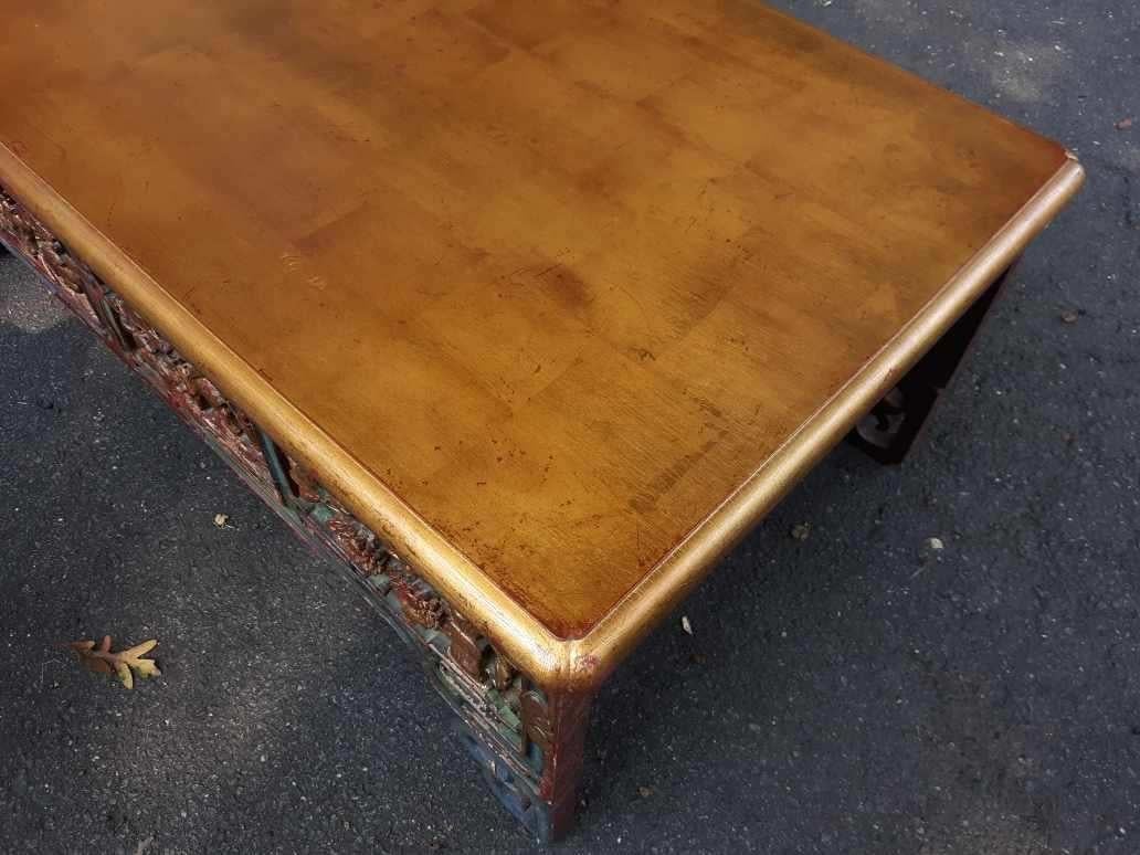 Cocktail coffee table with 19th century base made from hand carved parts of an antique bed. The later custom top with authentic hand embellished gold leaf.