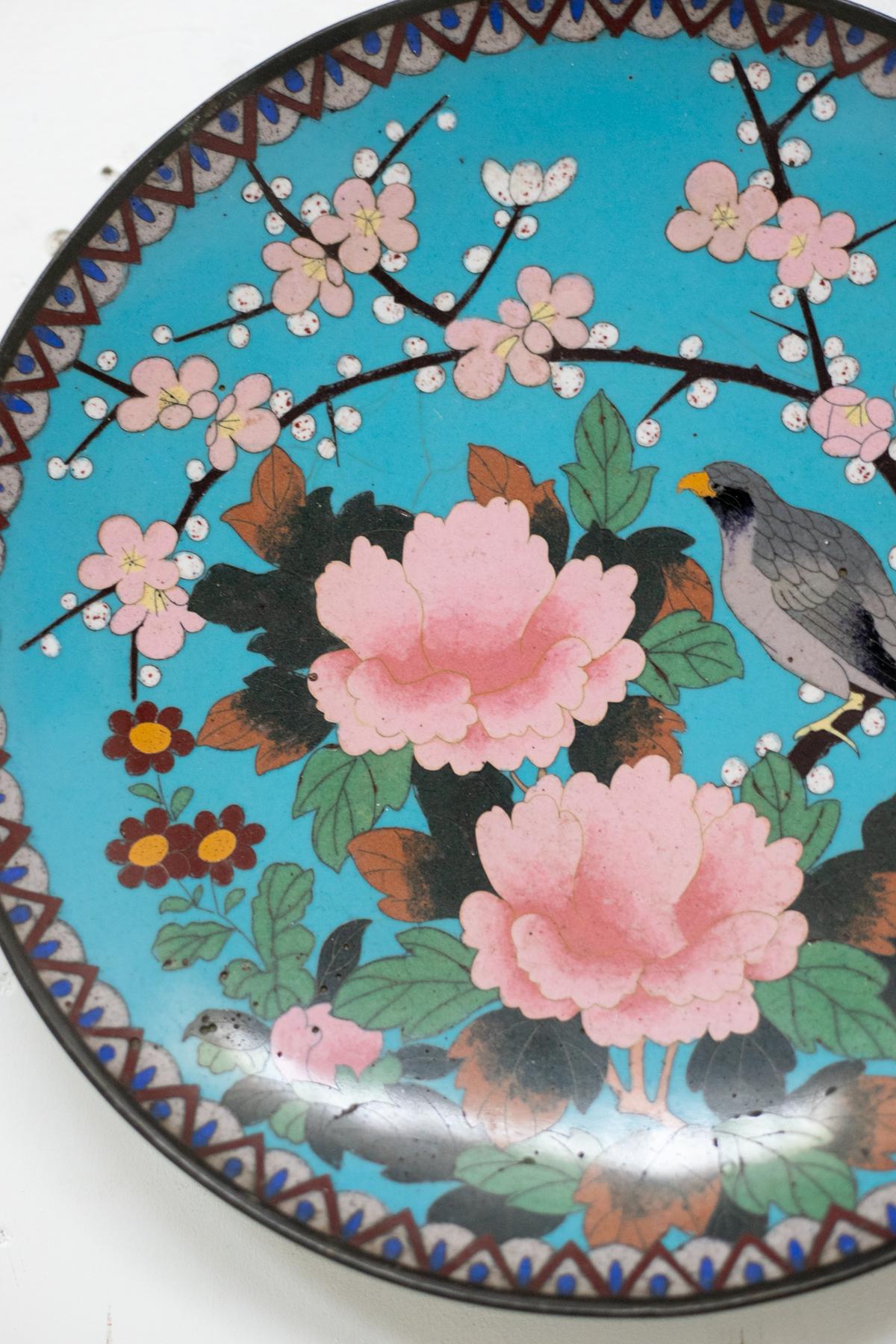 Round plate in bronze and cloisonné enamel designed in China in the 20th century.
This plate is made of bronze and cloisonné enamel, a goldsmithing technique originally applied to jewellery design. The polychrome decorations depict a sparrow