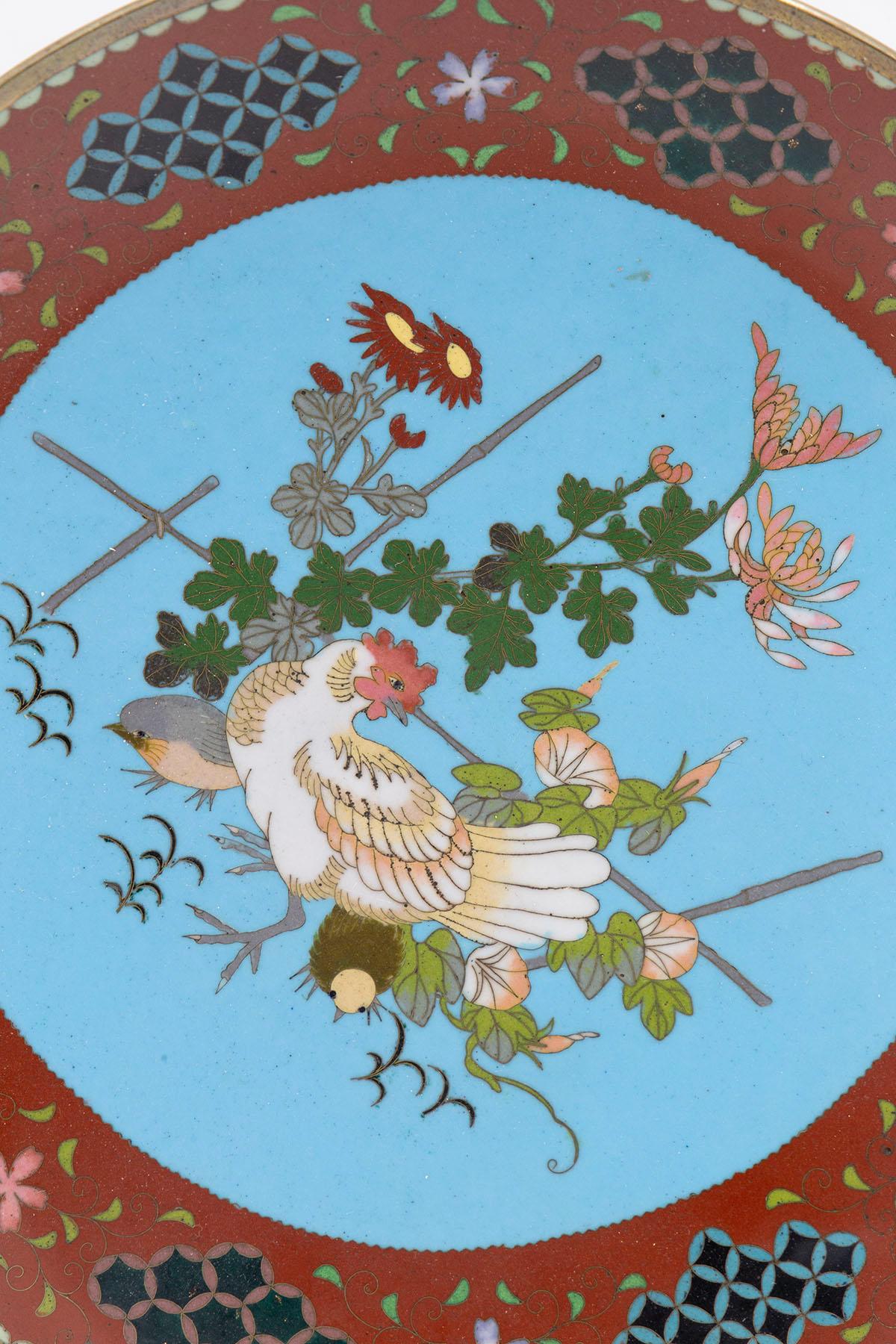Round plate made of bronze and cloisonné enamel designed in China in the 20th century.
This plate is made of bronze and cloisonné enamel, a goldsmith technique originally applied to jewellery design. The polychrome decorations depict a white