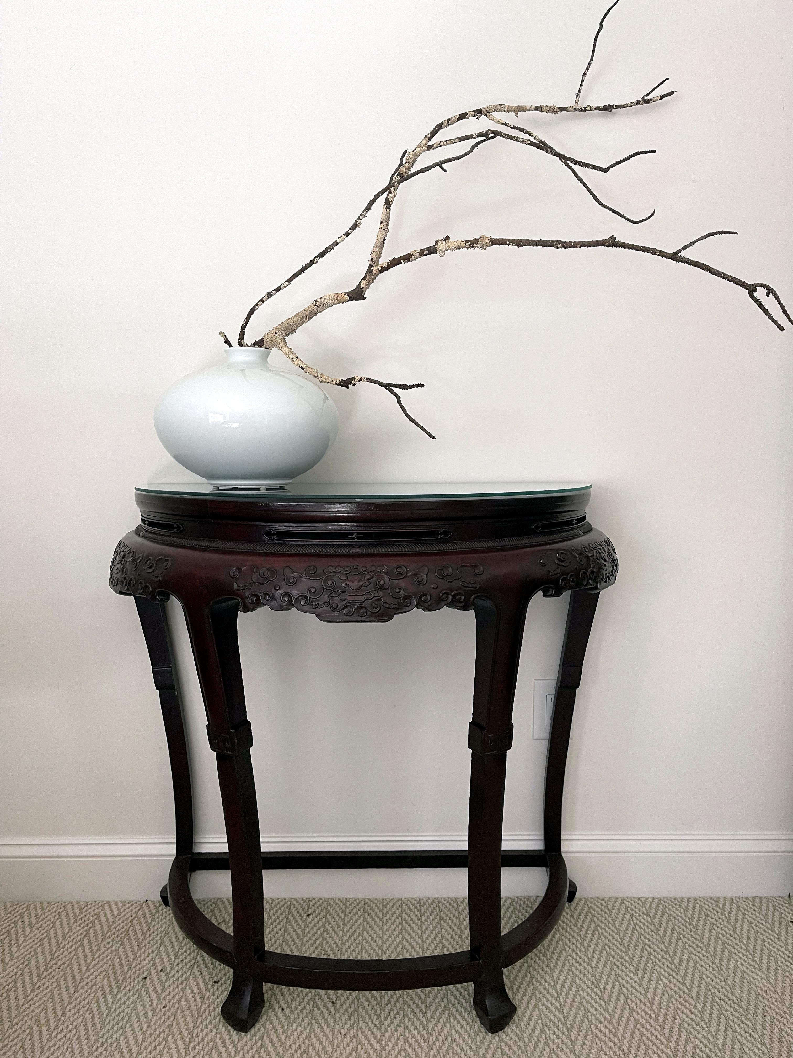 Ein chinesischer Demi-Lune-Konsolentisch aus der zweiten Hälfte des 19. Jahrhunderts (späte Qing-Dynastie; 1644-1912). Der D-förmige Tisch, der immer paarweise hergestellt wird, wurde so genannt, weil er einem Halbmond ähnelt, und wenn die beiden