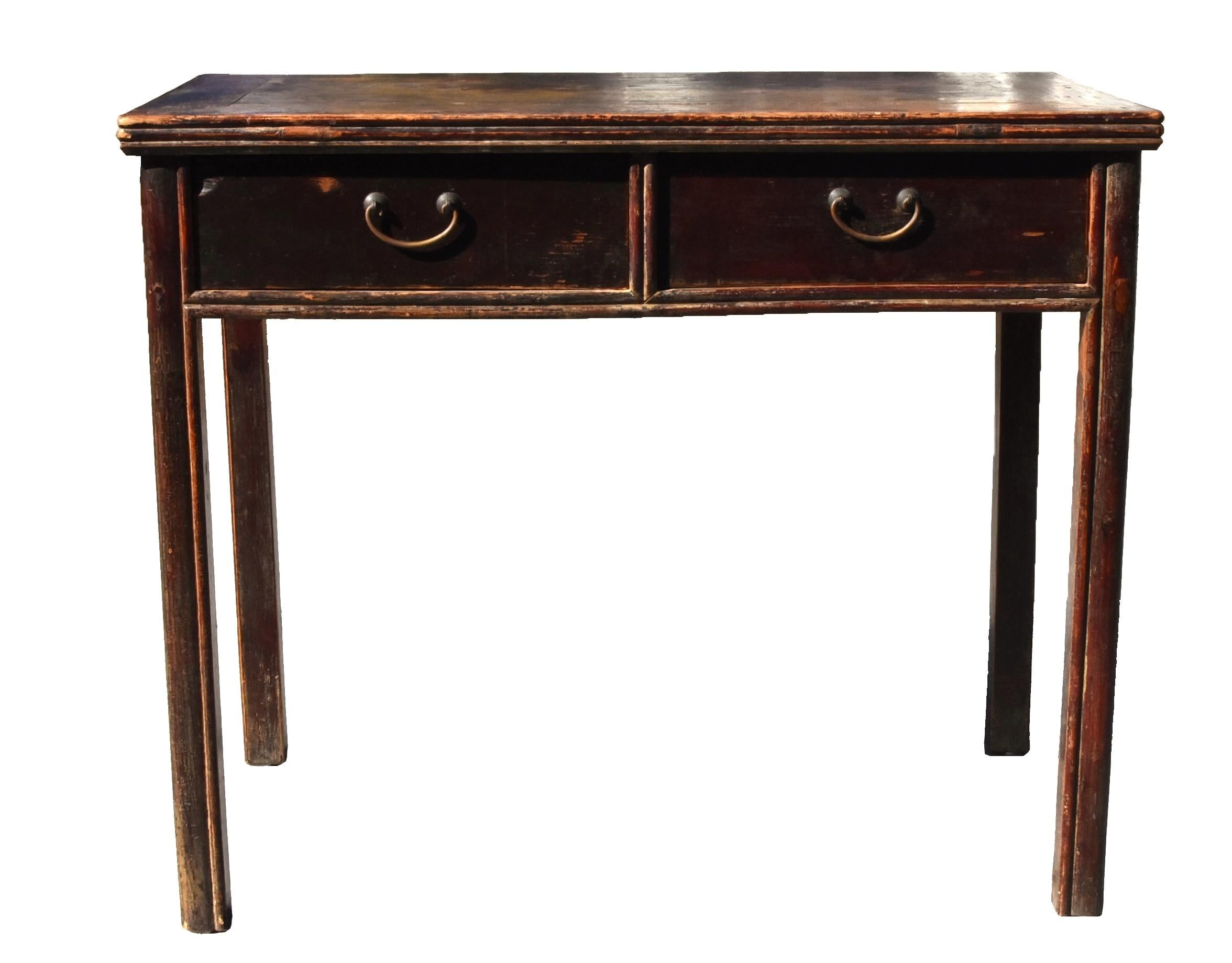 A solid wood Ming dynasty style desk with the top constructed of four members joined by mitered tenons and mortises in which a float panel is set. A pair of full size drawers anchor the desk beneath carved waist resembling bamboos. The same pattern