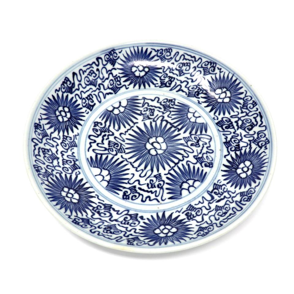 Antique Chinese Domestic blue-and-white stoneware plate, an almost white porcelaneous body with small inclusions, decorated in an under glaze cobalt blue naive interpretation of the Chinese Floral Scroll pattern with calligraphic vine tendrils and