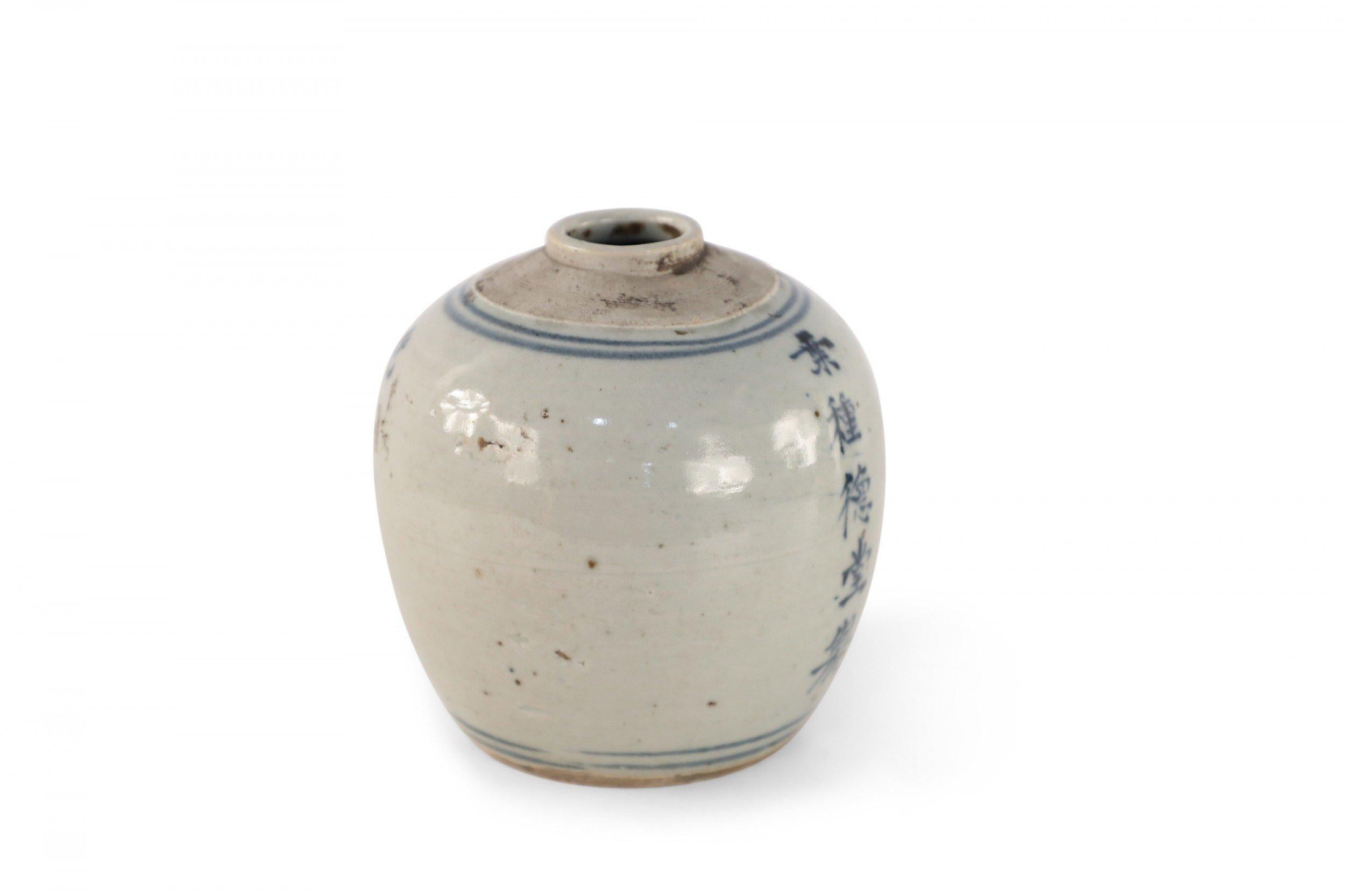 Antique Chinese (early 20th century) small, earthenware jar with blue characters running down the center framed by thin stripes circling the top and base.
     