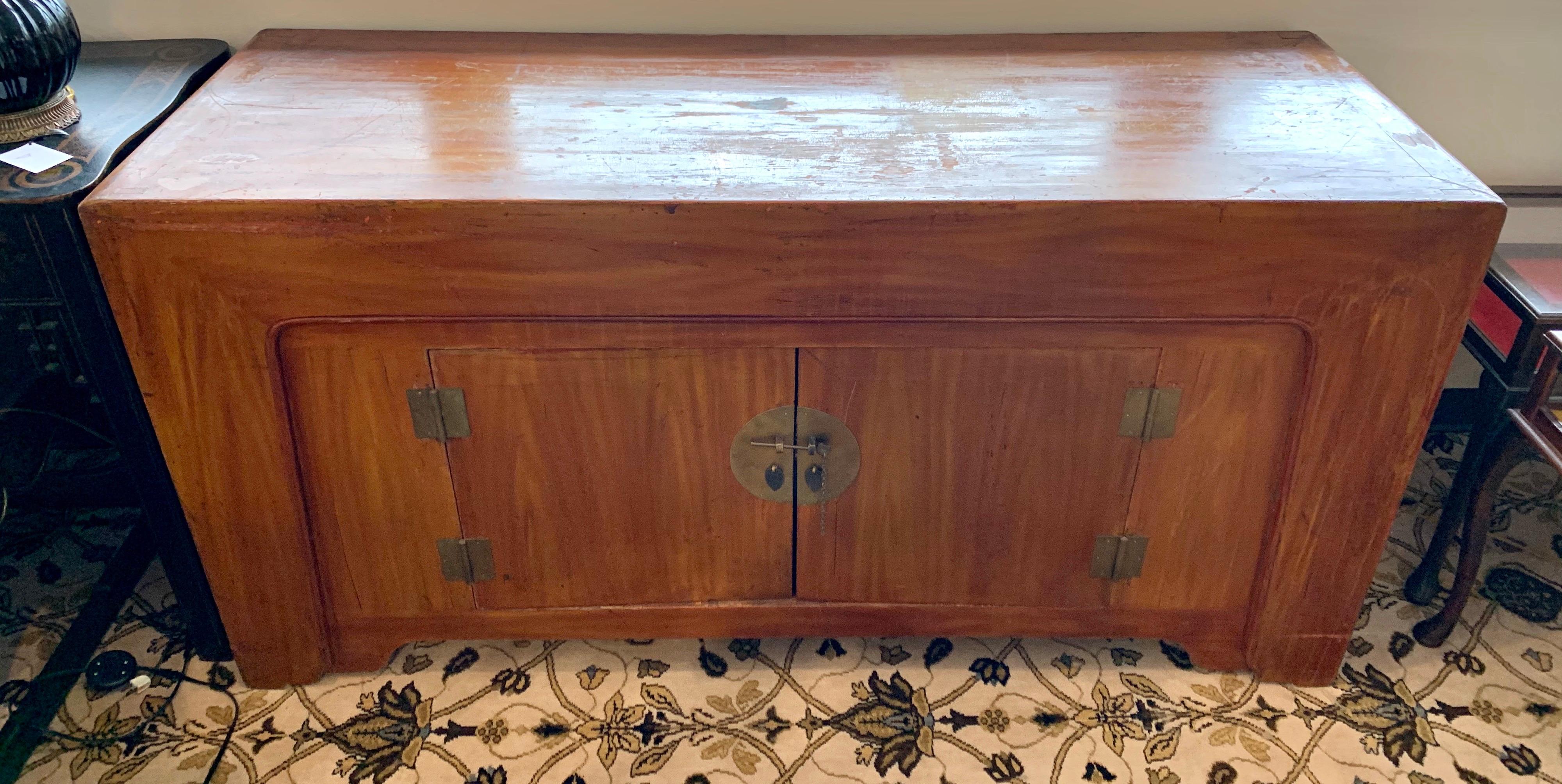 Late 19th-Century Chinese buffet credenza made of heavy solid elmwood boards with beautiful graining. A bronze central medallion anchors the chest flanked by two bronze hinges. Center doors open to storage with hidden storage underneath, behind a