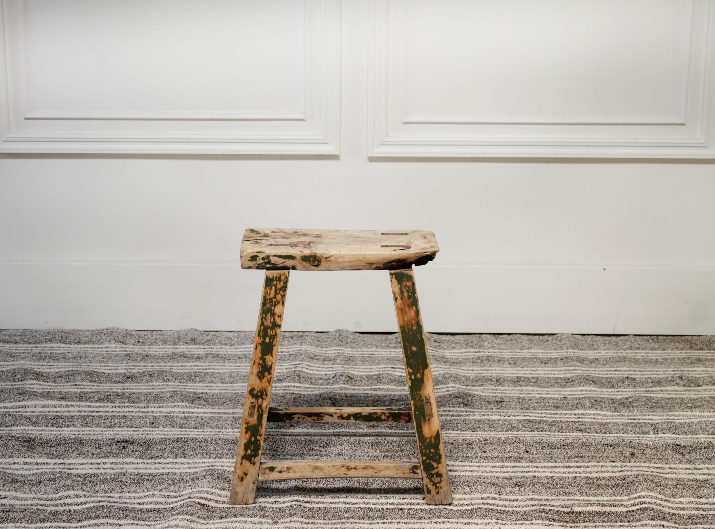 Antique Chinese elmwood painted stool
Original paint on some areas that has been weathered away. A dark green color fading to expose a natural light elmwood. We love using these next to a sofa as a side table, in between chairs or even in a bath